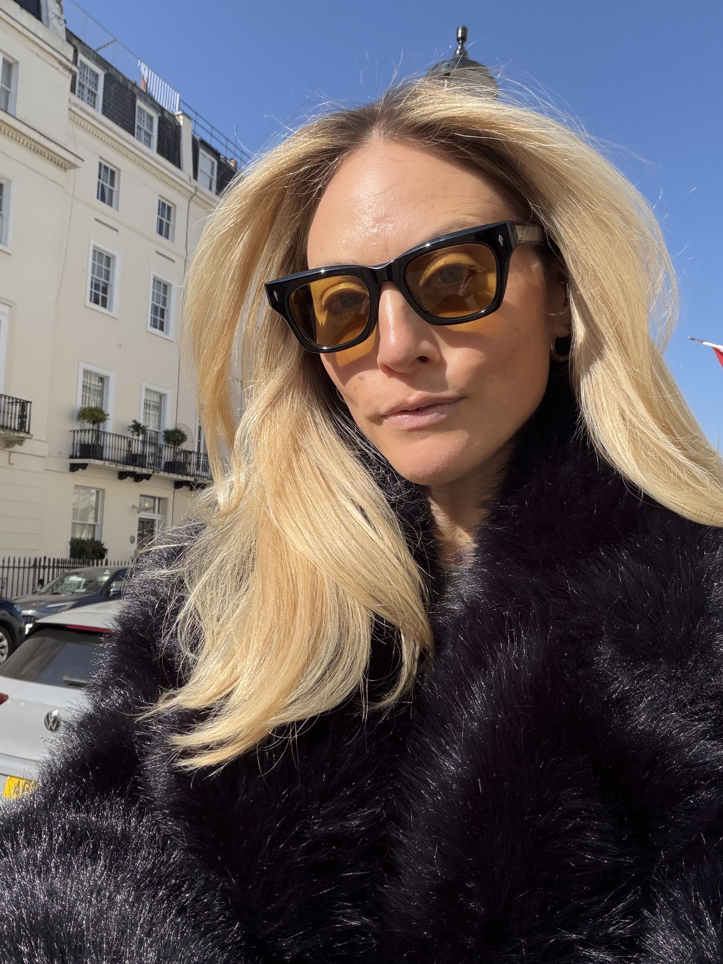 Brooke Ely Danielson wearing a faux fur coat and wearing light tint sunglasses