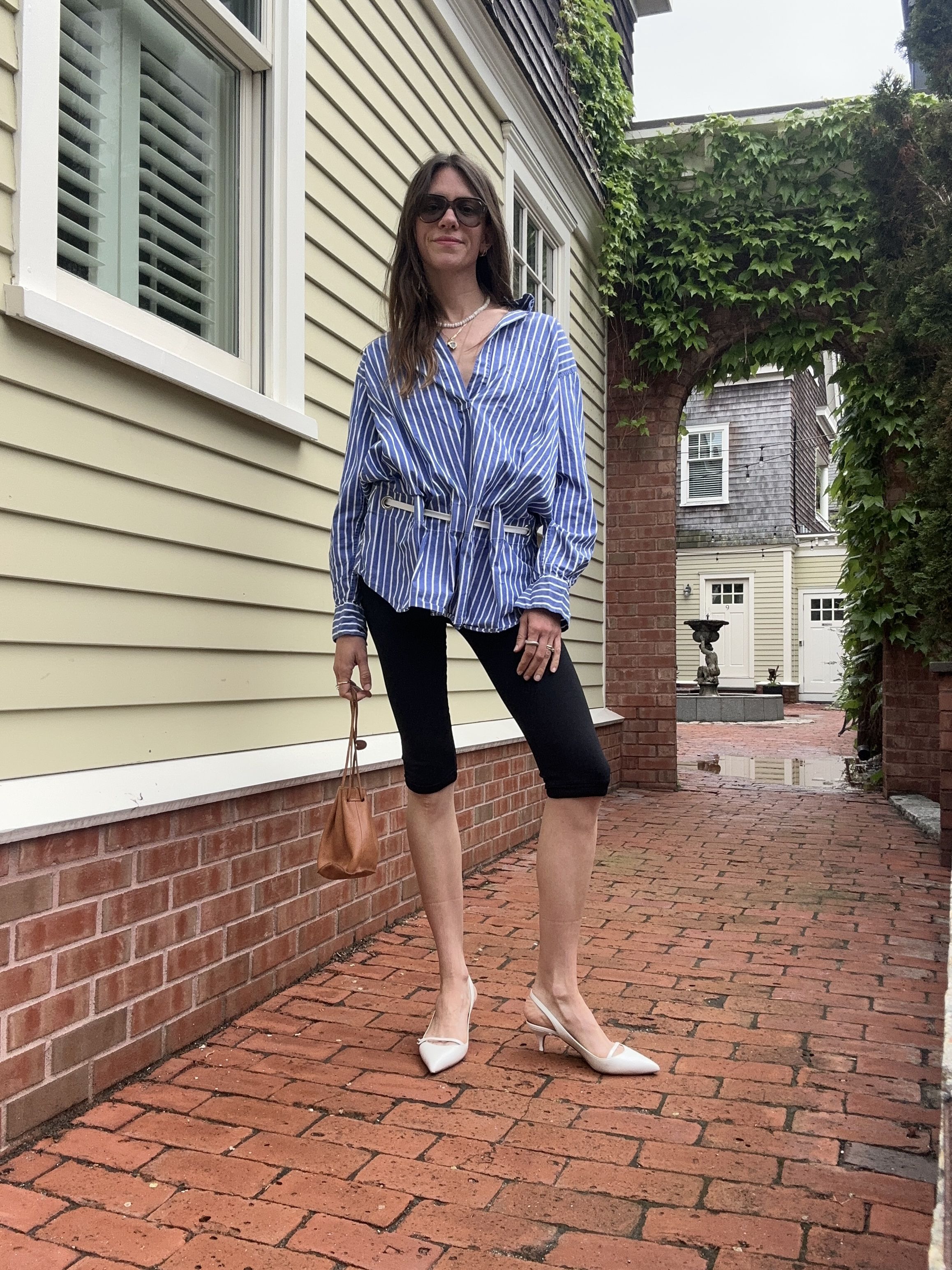 Julia Gall wears black capris with a cinched waist button-down shirt and kitten heels