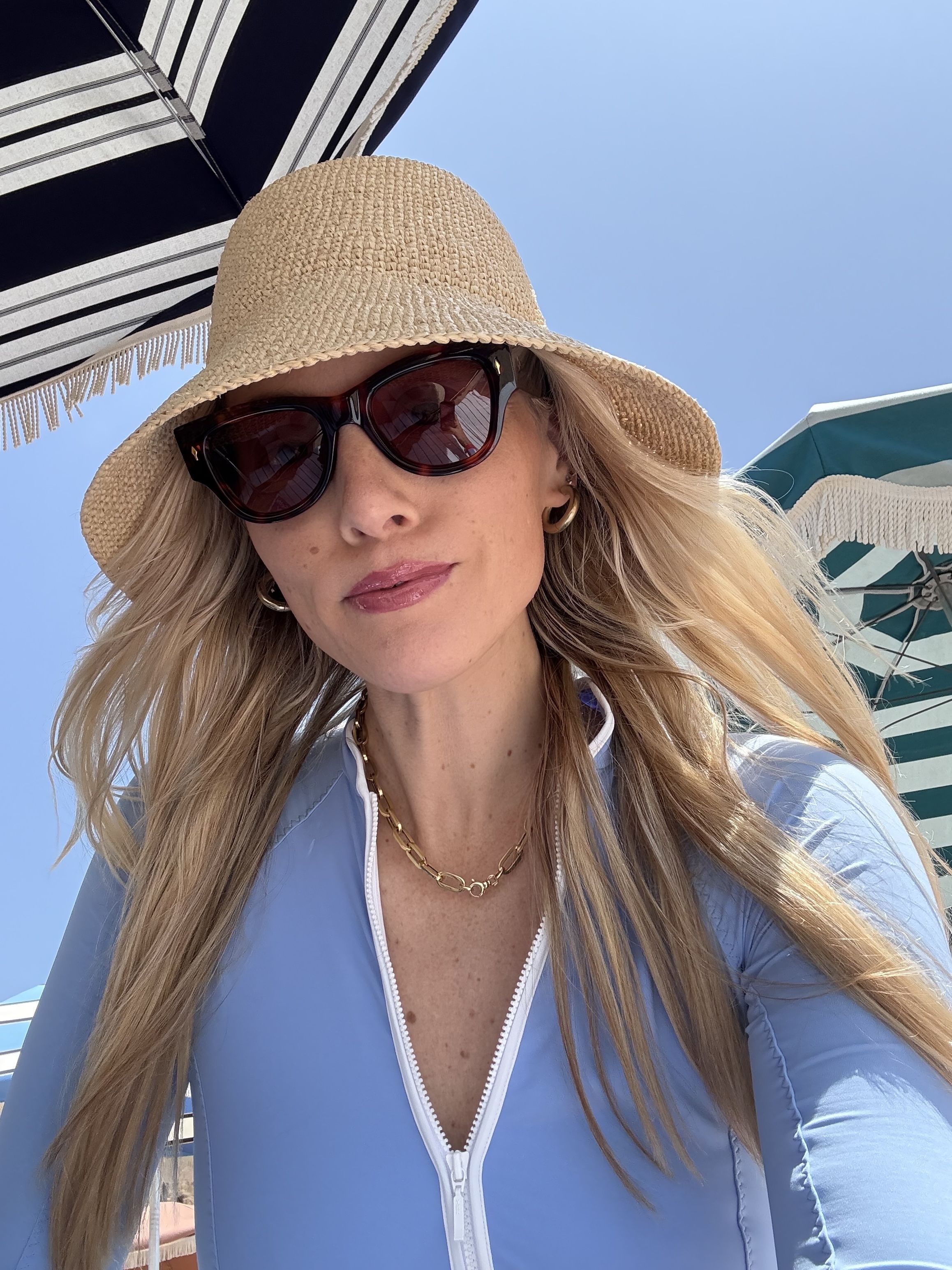 Brooke Ely Danielson wears a cloche straw hat on the beach