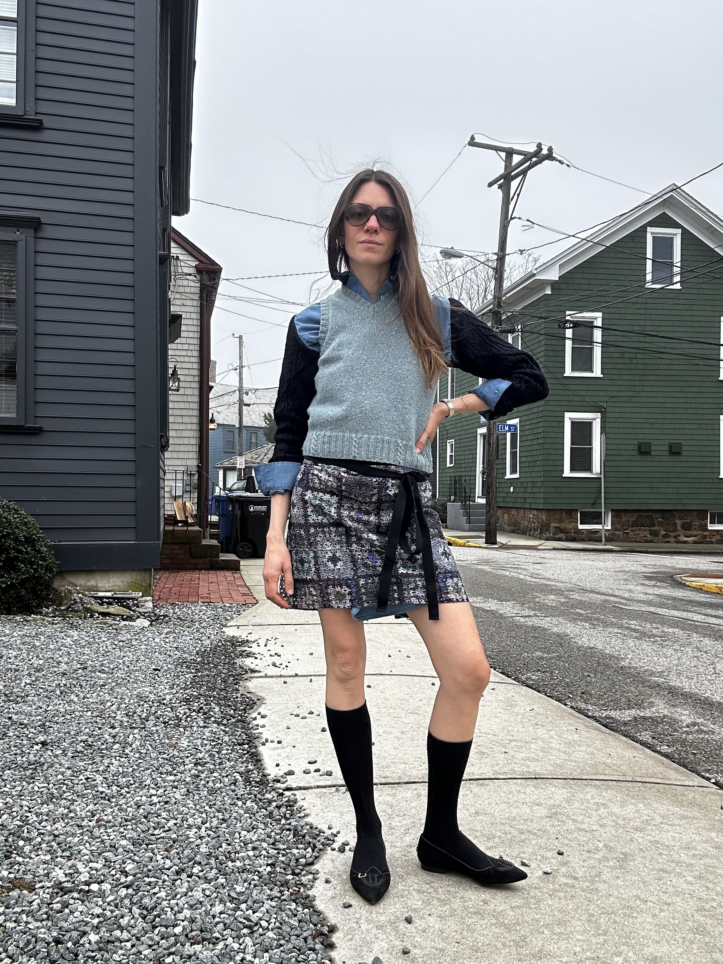 Julia Gall completes the layered look with a sweater vest and printed mini skirt
