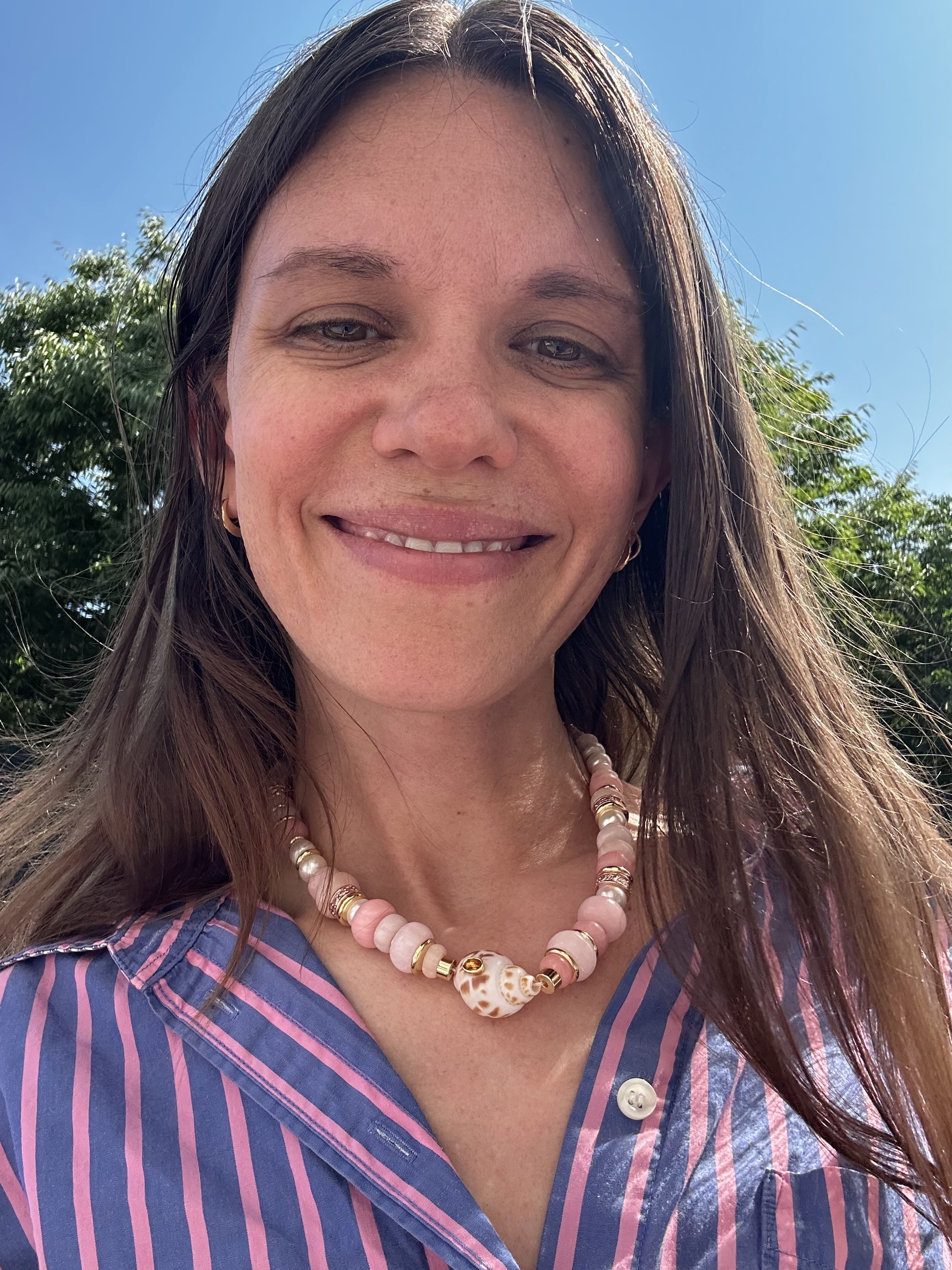 Julia Gall wears a chunky seashell necklace with a striped shirt