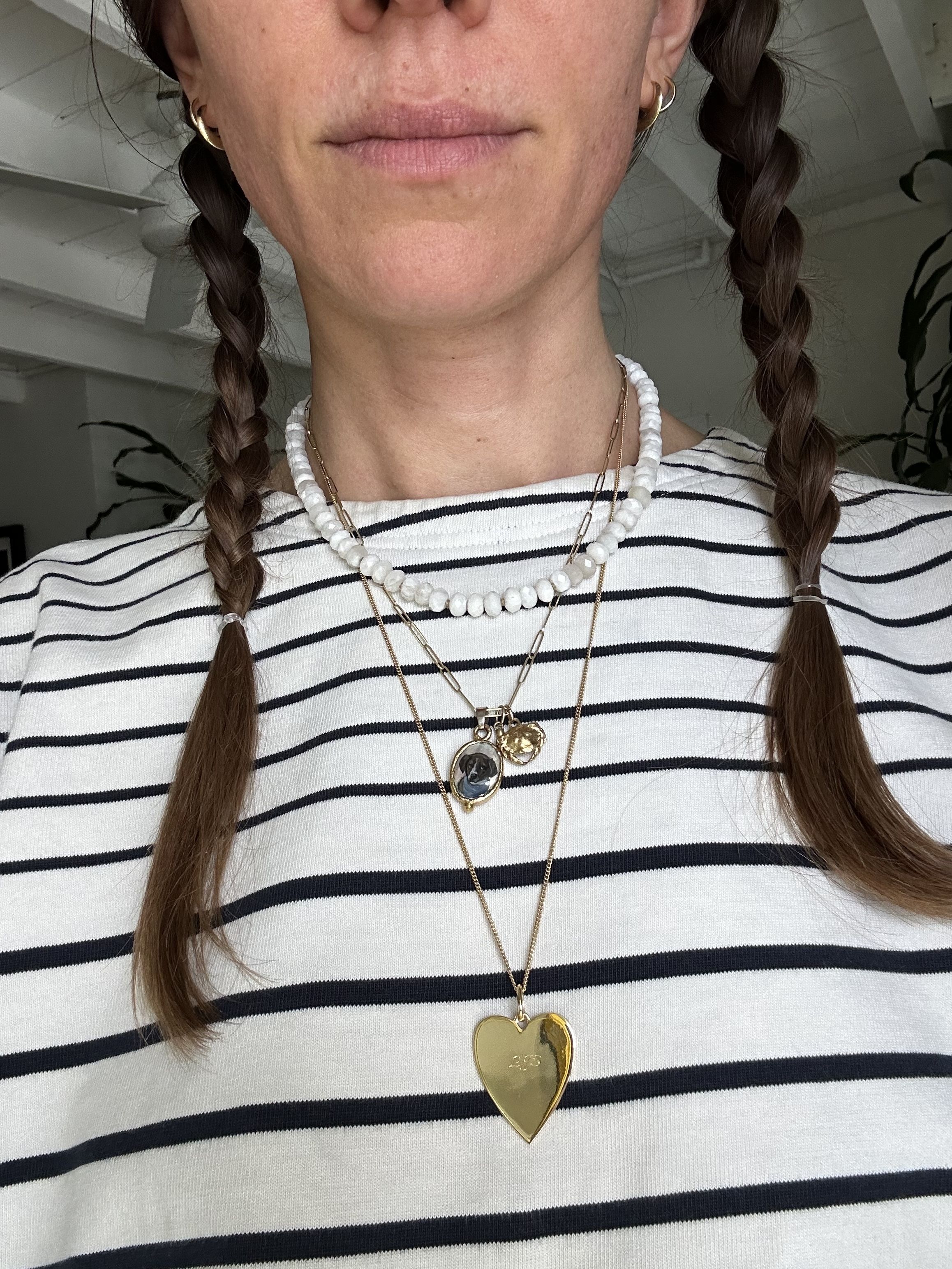 Julia Gall wears a long heart-shaped engraved pendant