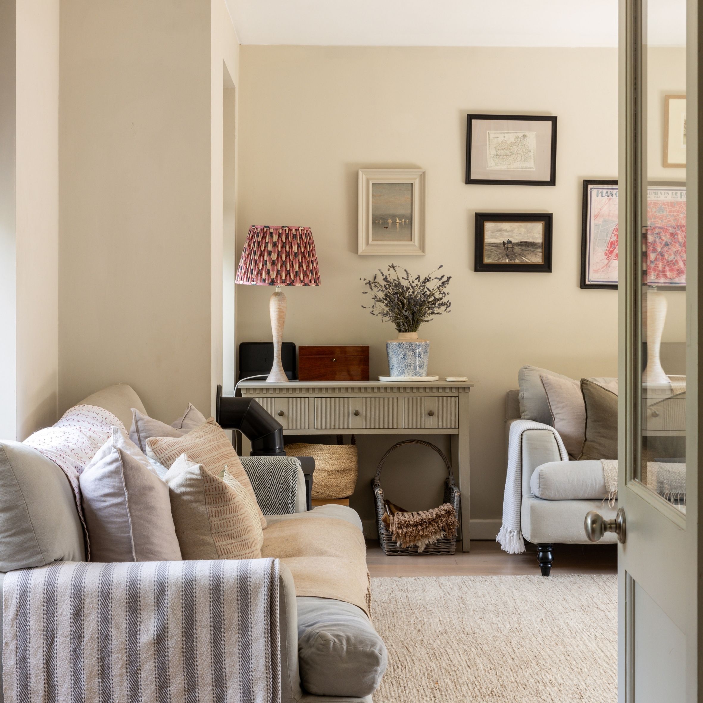 Living room with grey sofas, side board, pink lamp and gallery wall