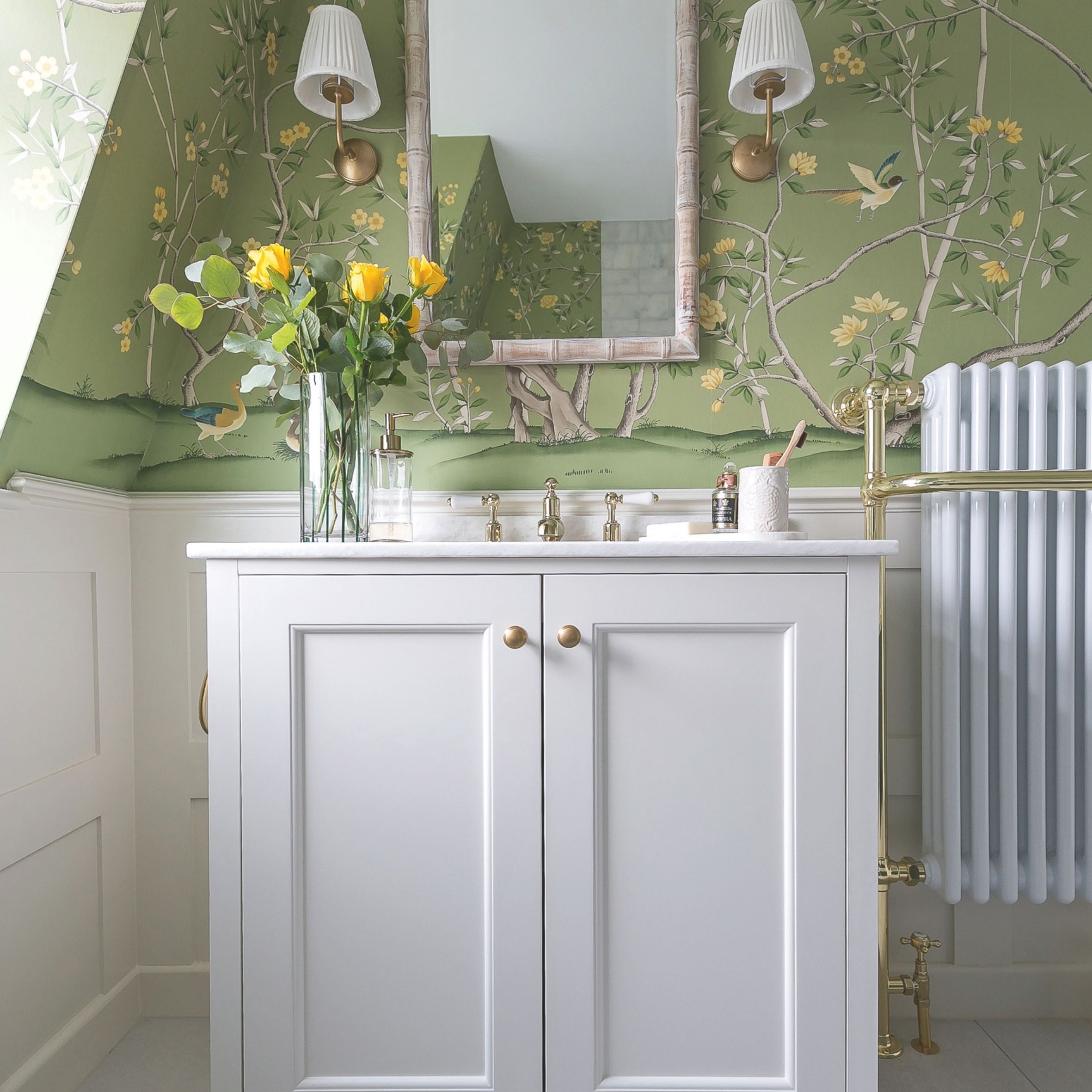 Bathroom vanity in white, marble top and green wallpaper behind