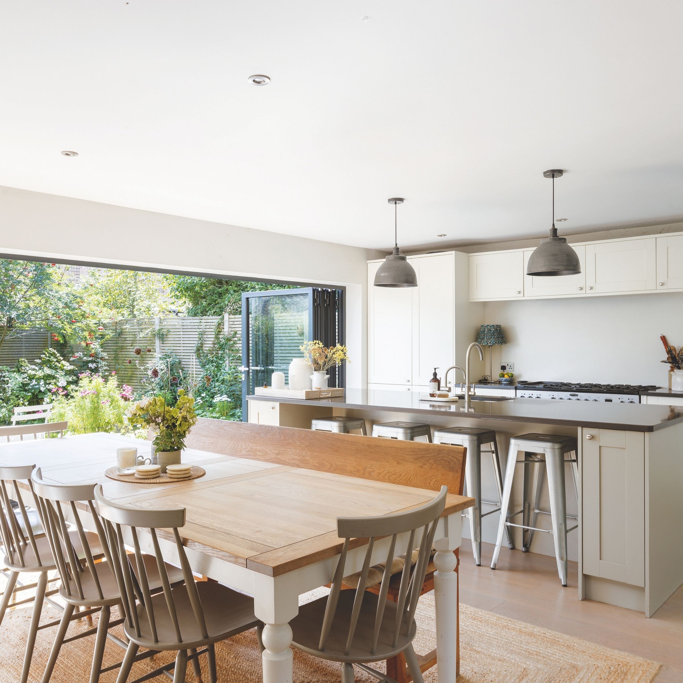 Kitchen diner with bifold doors, jute rug and wooden table