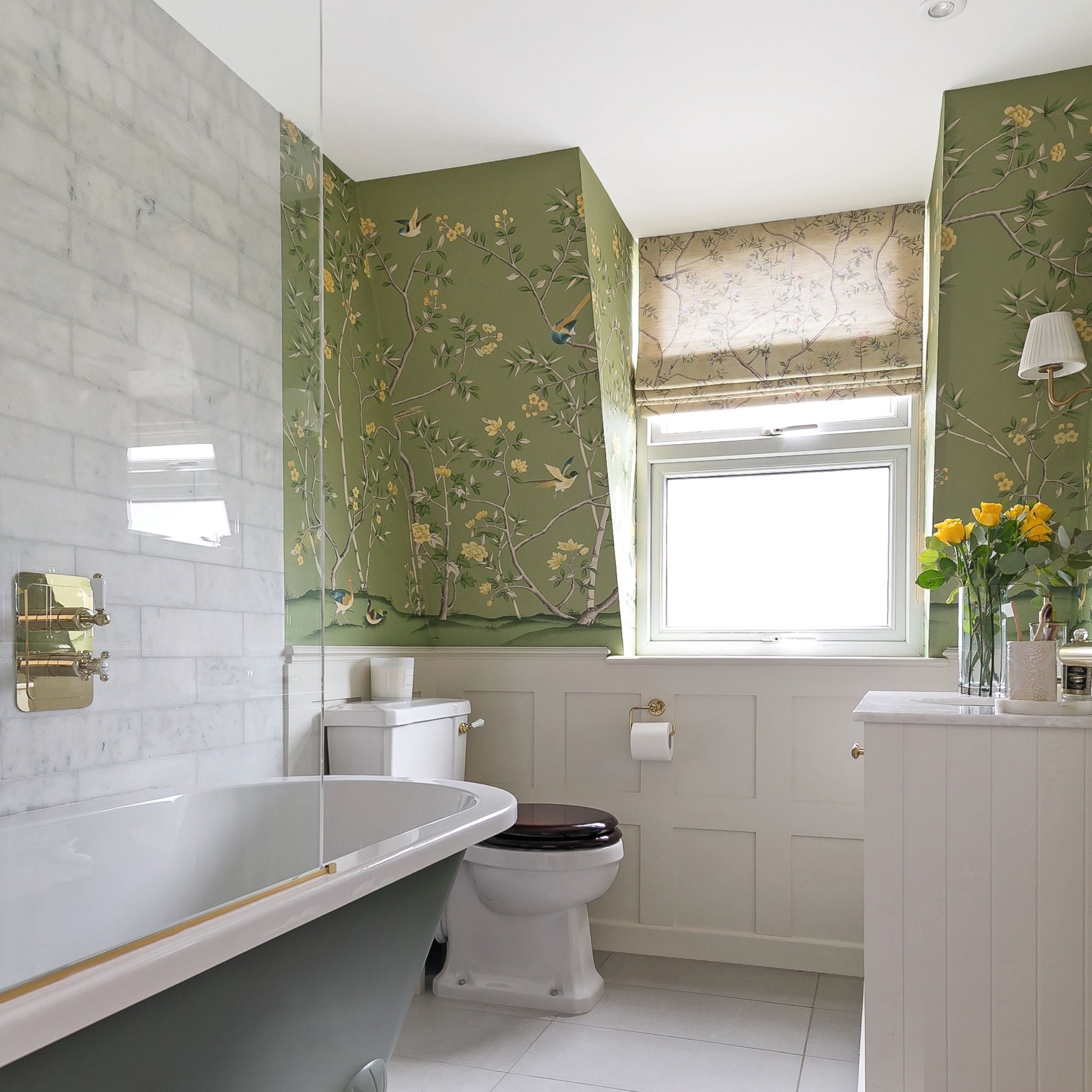 Green bathroom with floral wallpaper, marble metro tiles, roman shade and freestanding tub