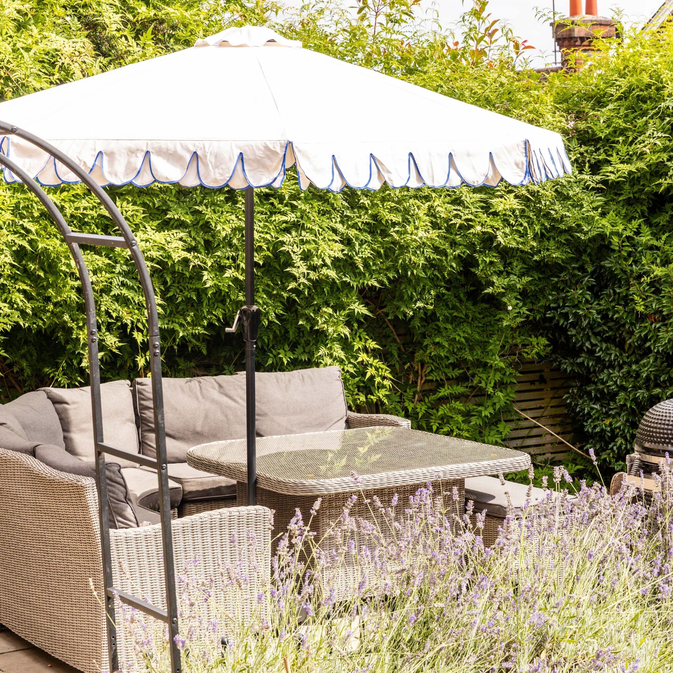 Garden with rattan furniture, dining table and white parasol