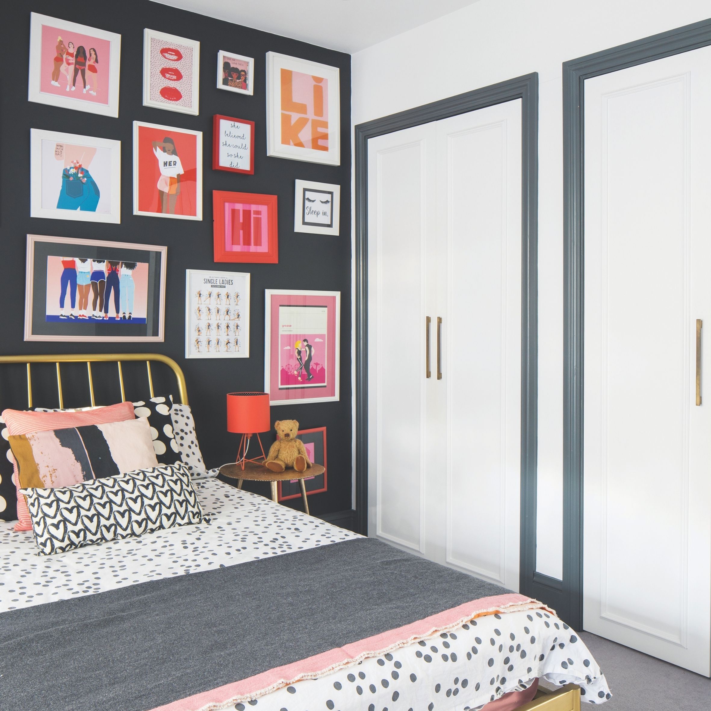 Kids' room with gold metal bed frame, double built-in wardrobe and black gallery wall