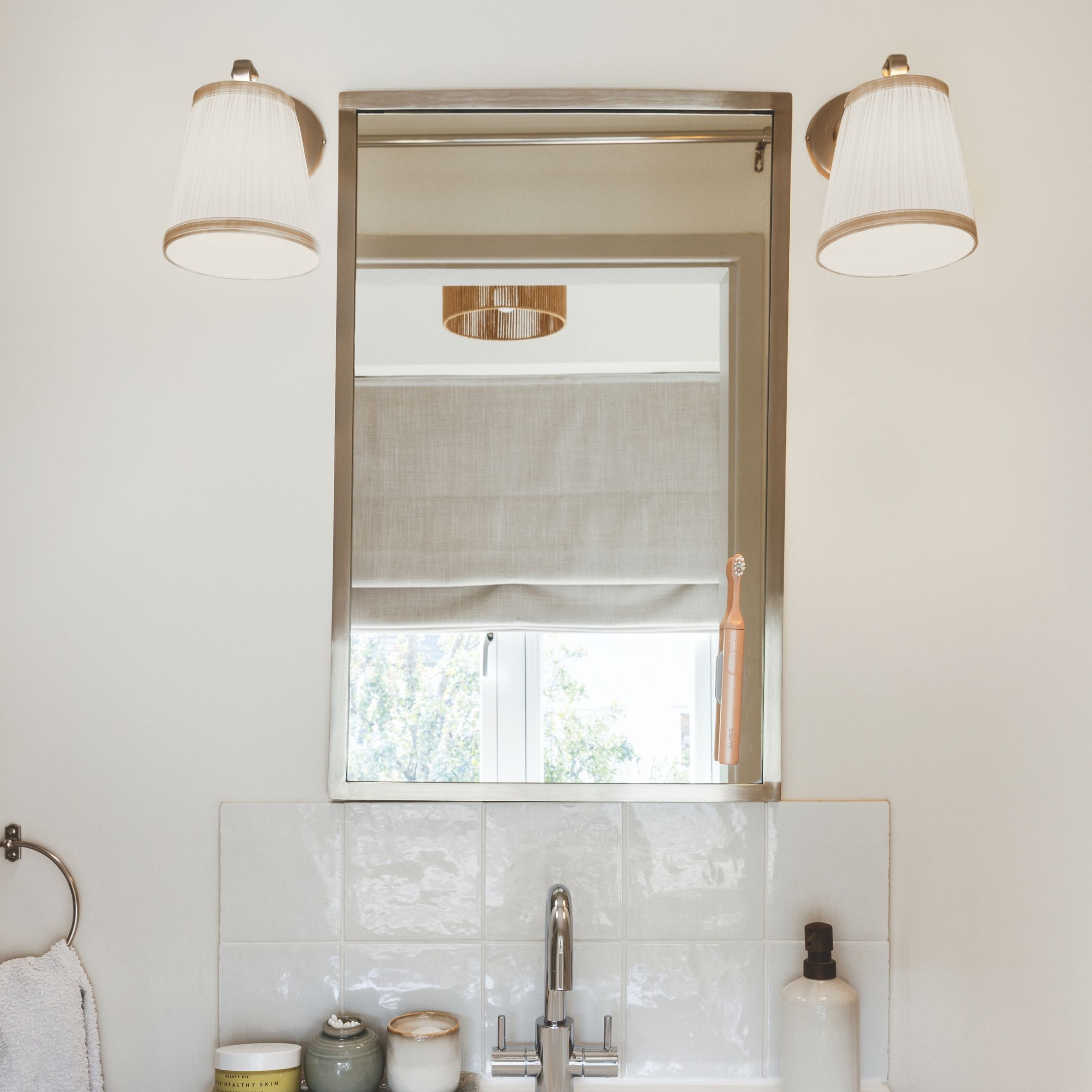 Small en suite unit with mirror and 2 lights above it