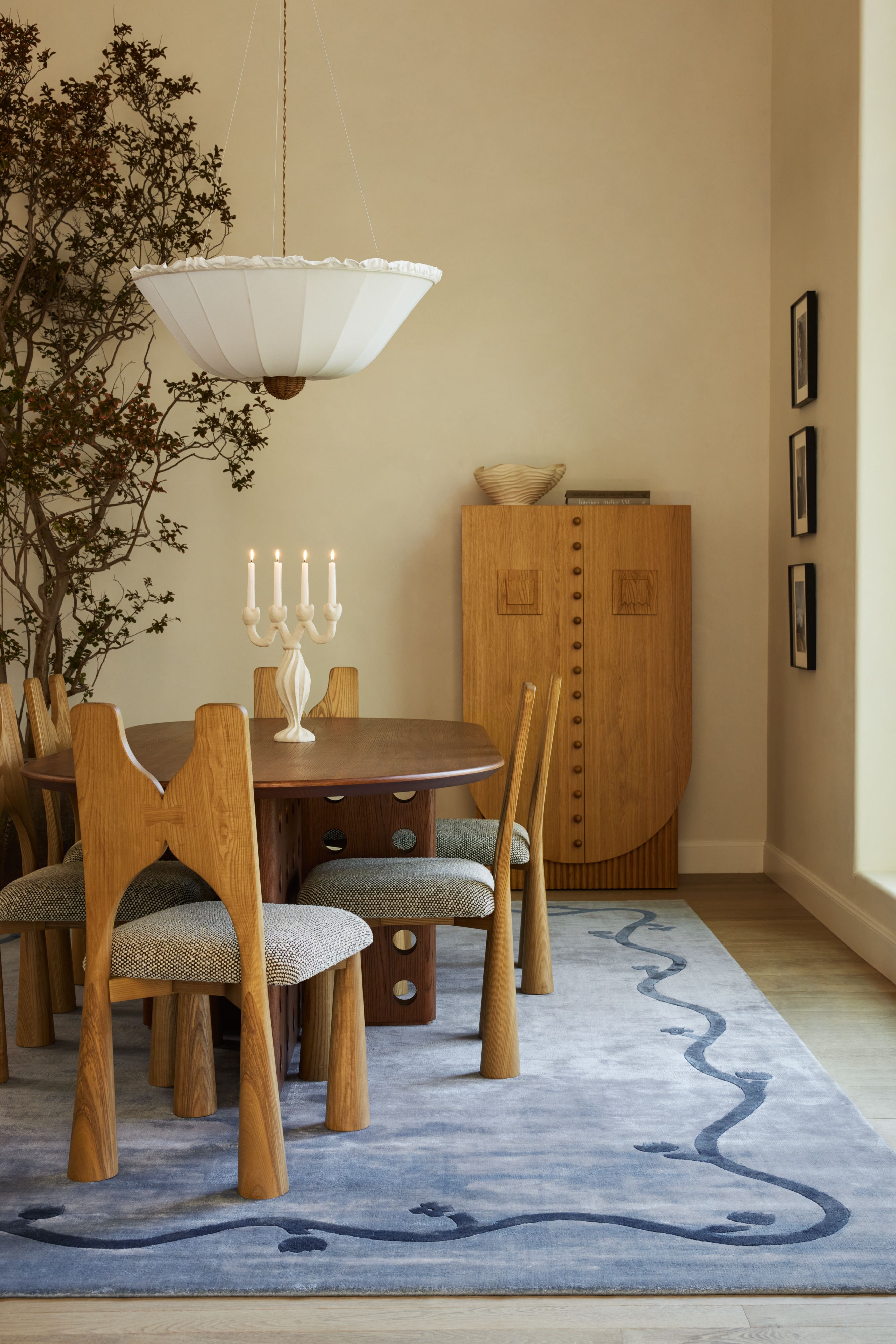 Dining room featuring a blue area rug, wooden fining furniture, and a twisted ceramic candelabra