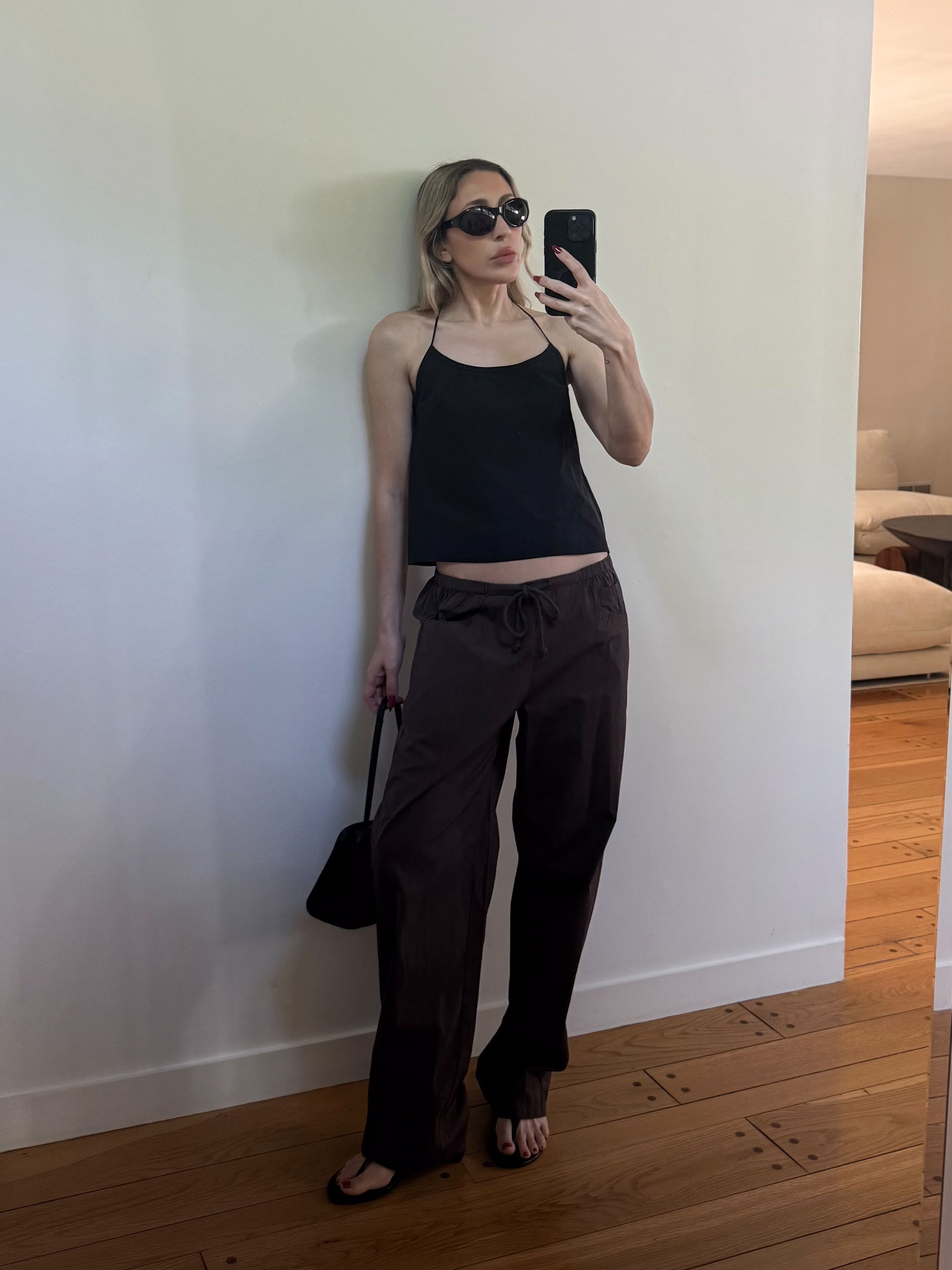 Angela Fink styles espresso drawstring pants with a simple black tank and dark glasses