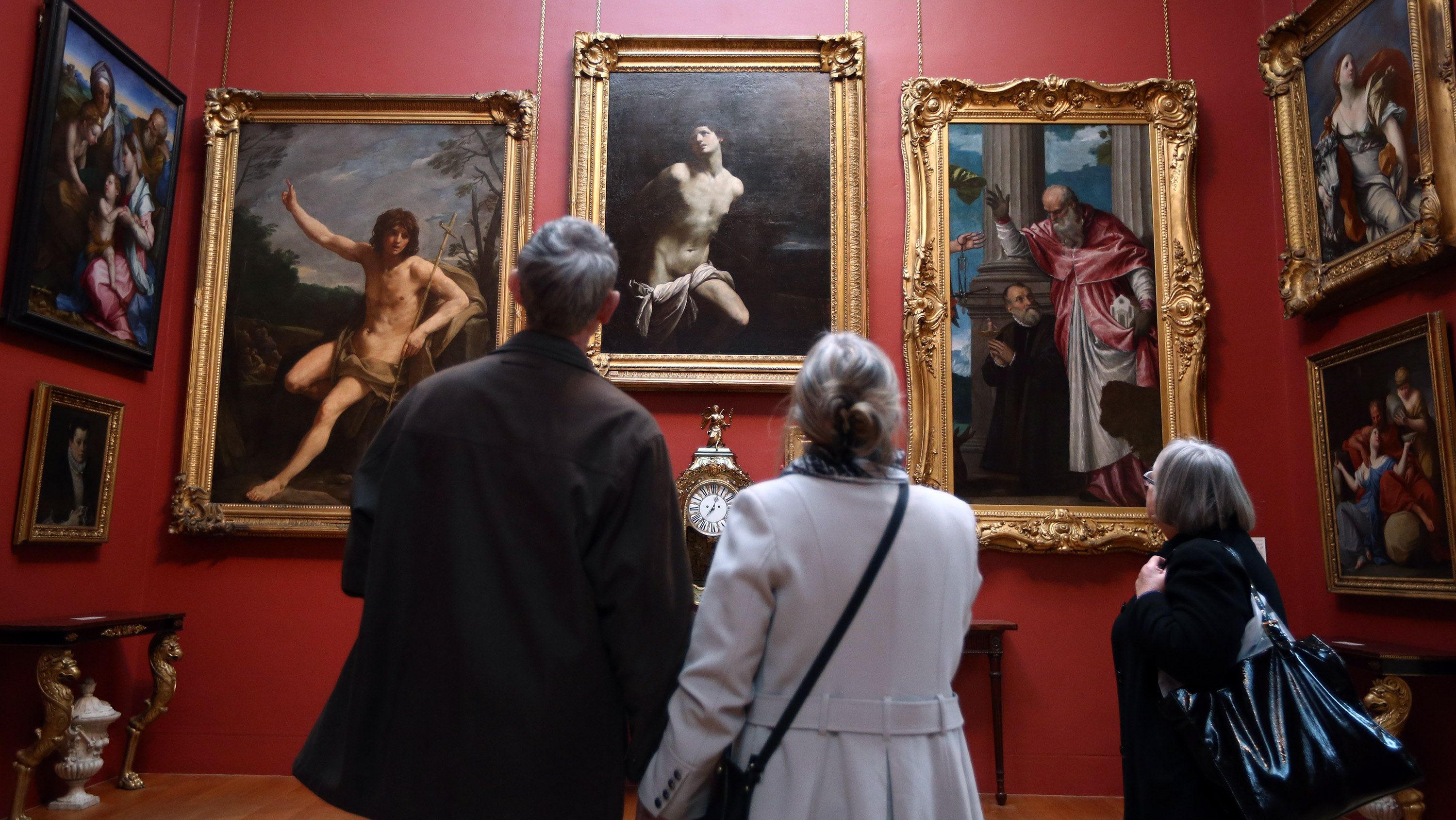 LONDON, ENGLAND - FEBRUARY 10: Visitors view paintings at the Dulwich Picture Gallery on February 10, 2015 in London, England. Working with U.S artist Doug Fishbone the gallery is encouraging the public to take a closer look at their permanent collection by replacing a painting with a replica sourced from an artists workshop in China and hung in the frame belonging to the original. For three months the identity of the work will remain concealed and visitors are invited to find the replicated painting. Winning answers will be entered into a draw to win one of five print-on-demand reproductions of chosen works in the Gallery's collection. The answer will be revealed on 28 April when original and replica will hang side by side. (Photo by Carl Court/Getty Images)