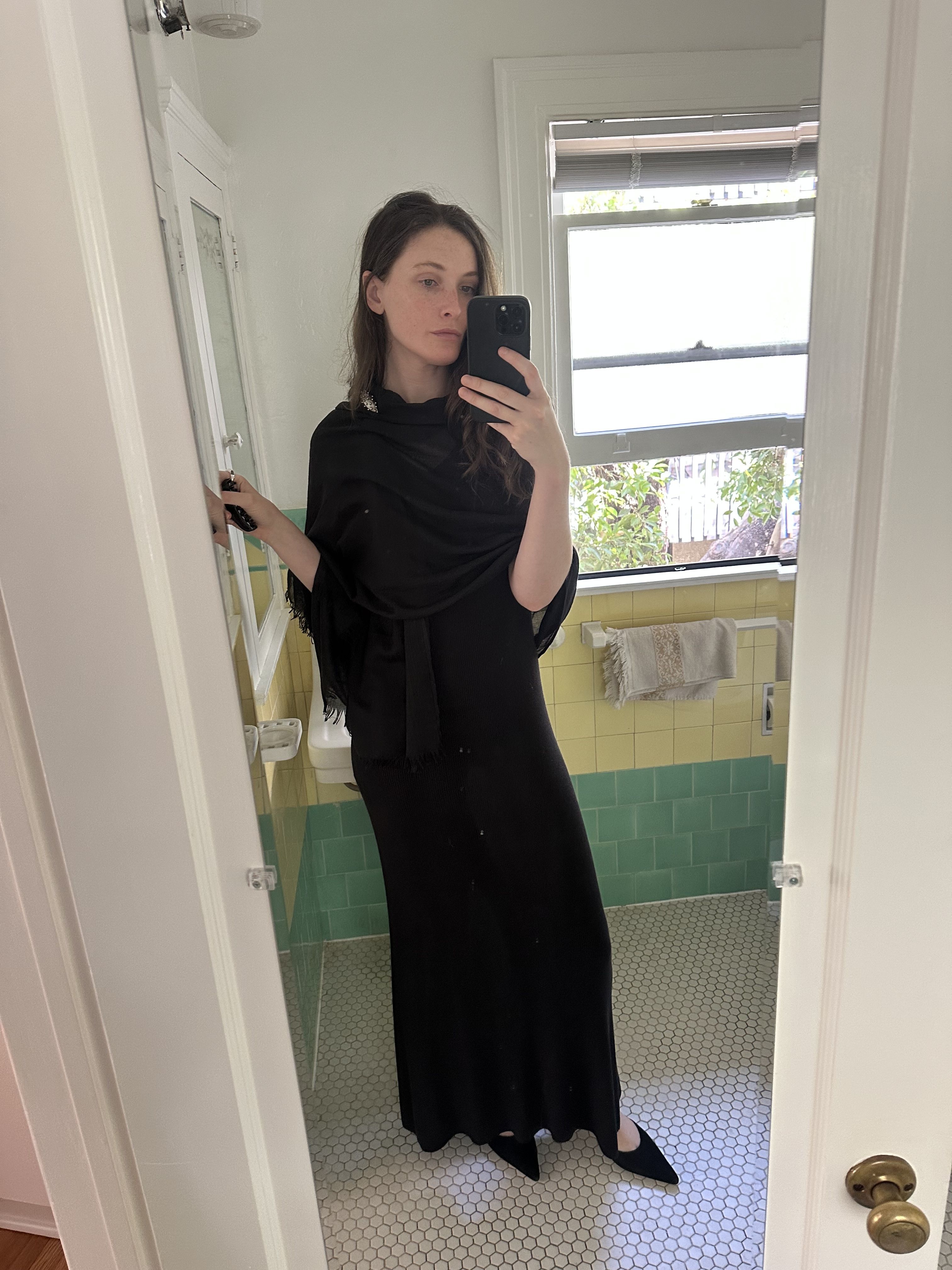 Grace O'Neill Dougherty wears a long black dress with pointy black pumps