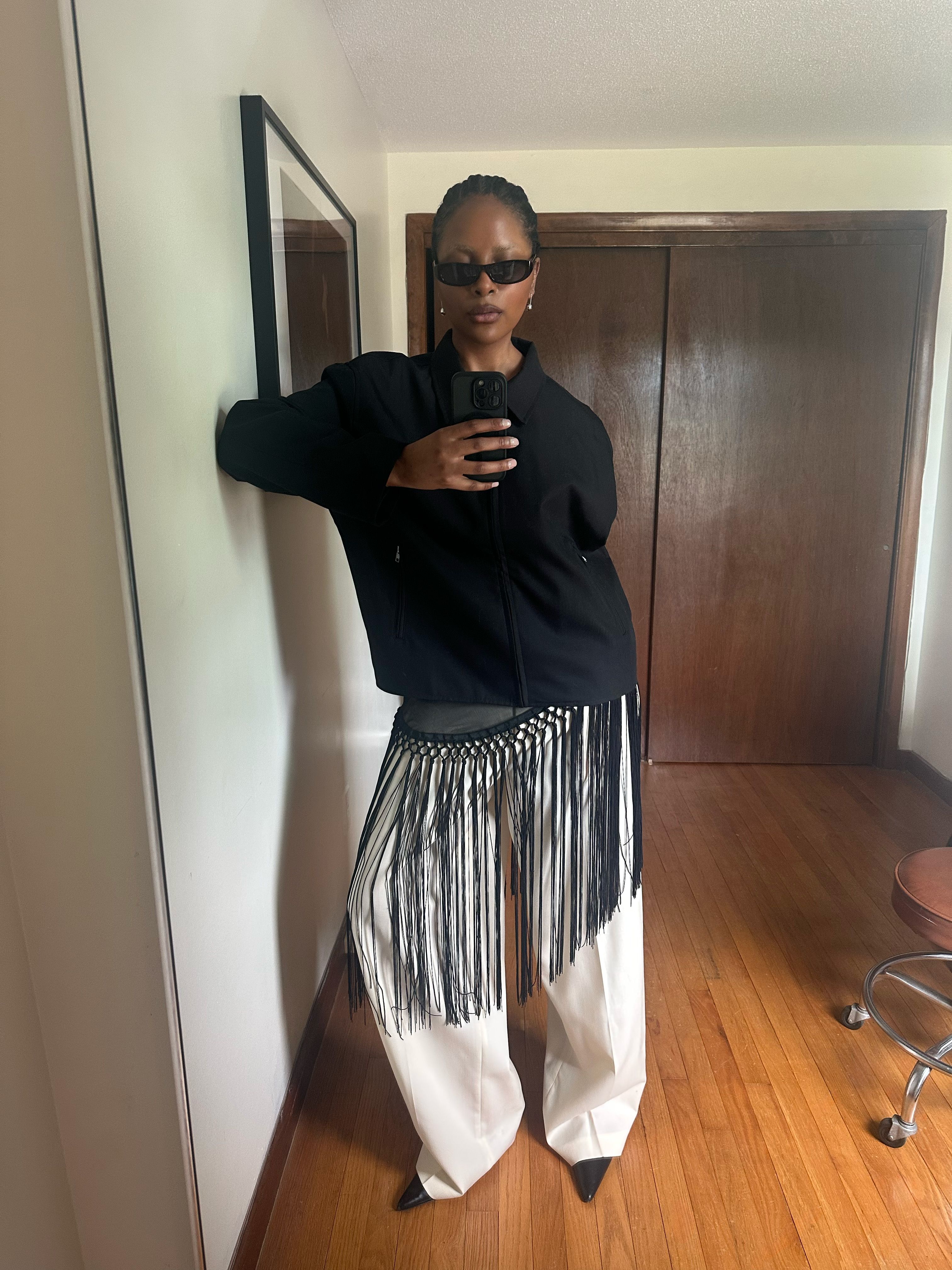 Maya Moore wears a fringe top over white trousers
