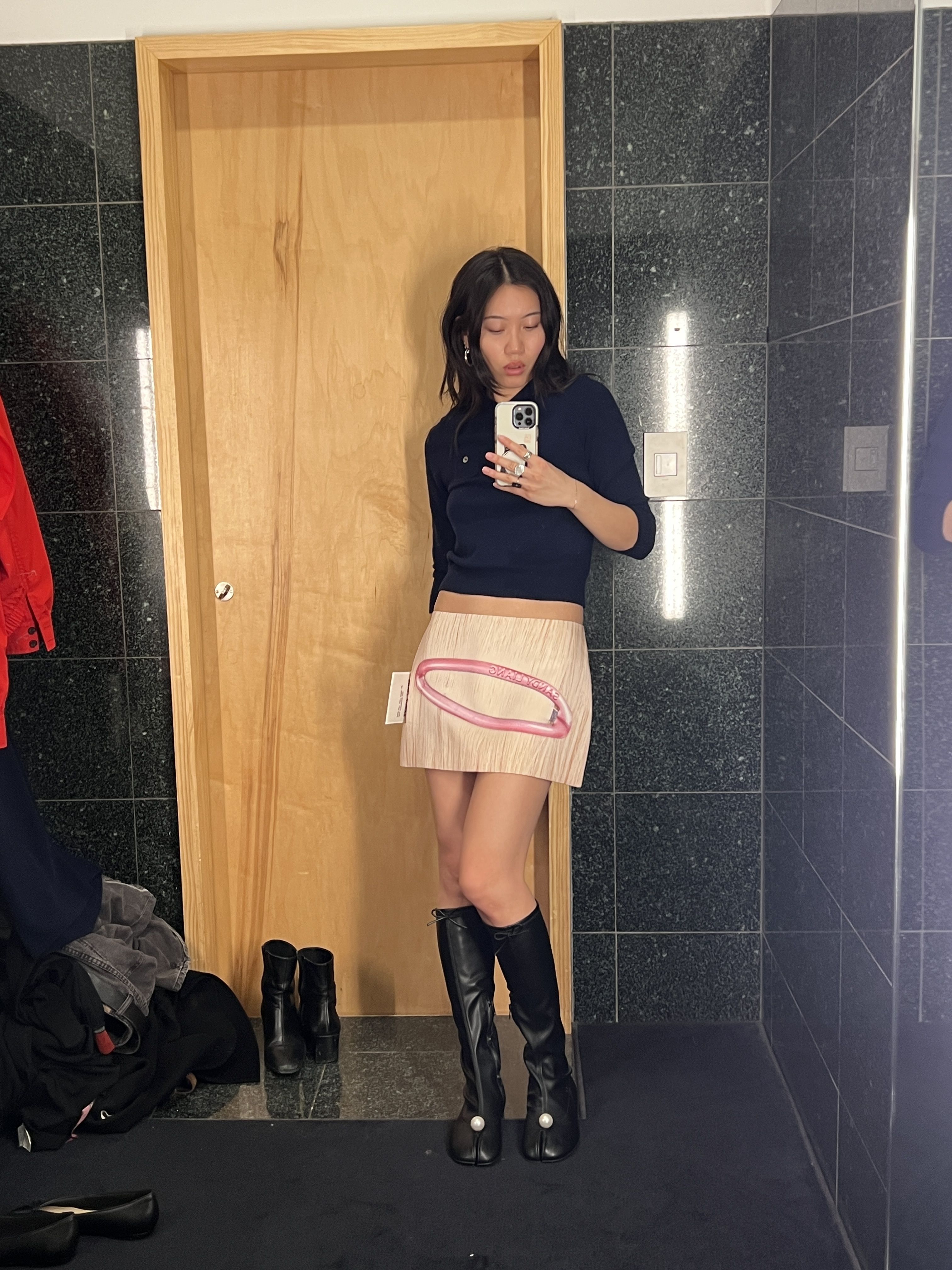 Vivian Li wearing a Sandy Liang sweater and taking a mirror selfie