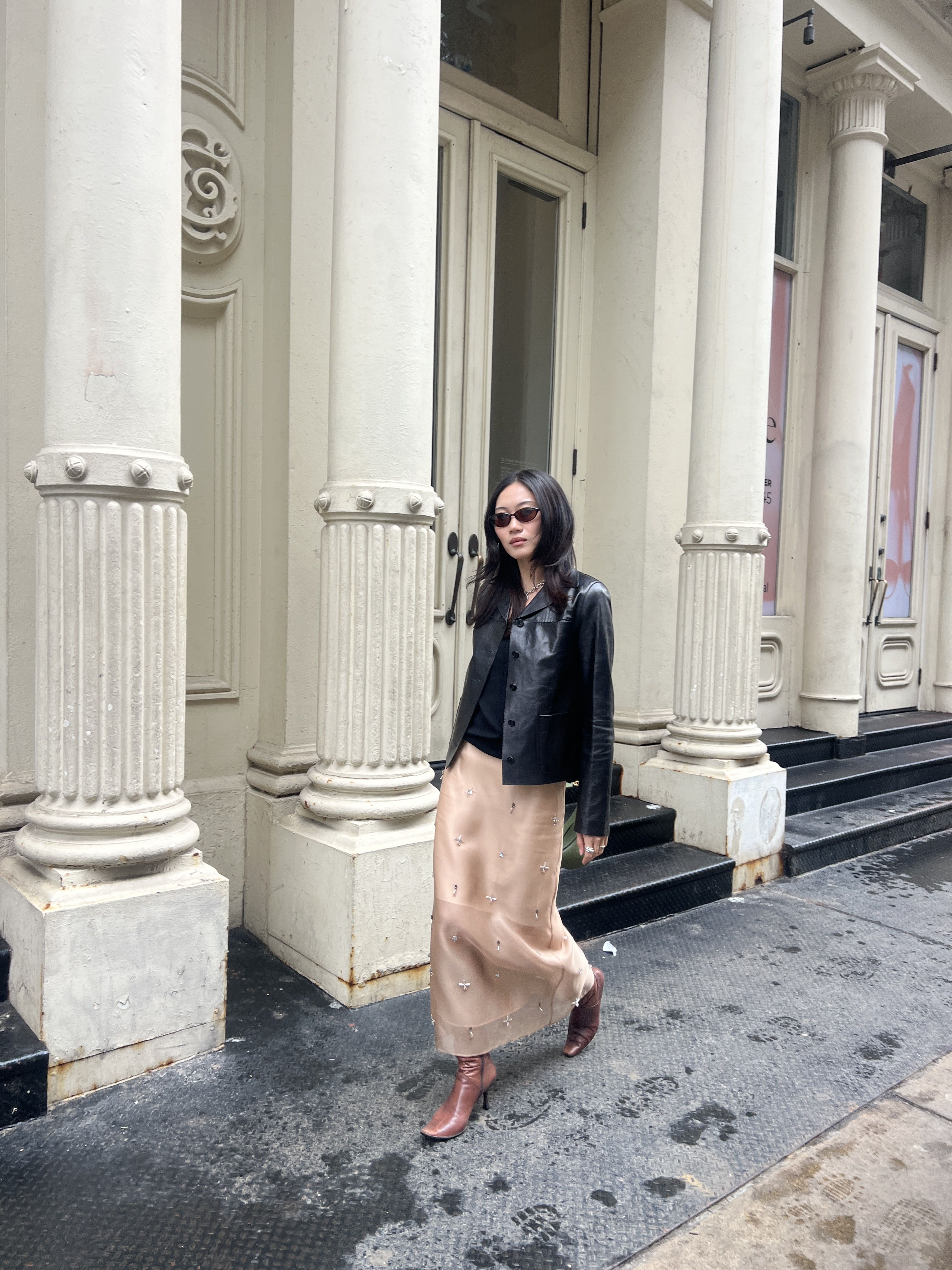 Vivian Li wearing a silk skirt and leather jacket on a street in New York