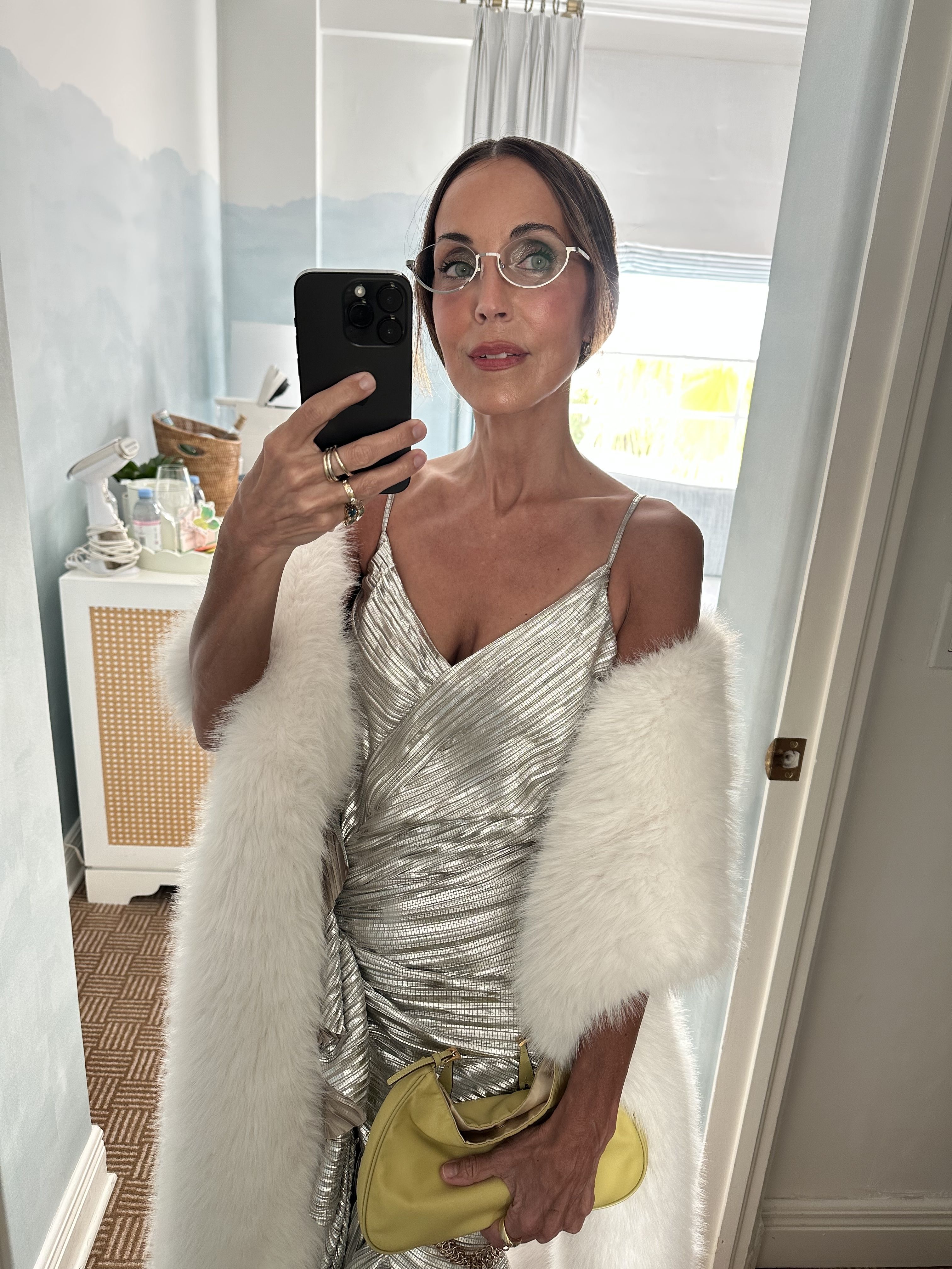 Larissa Mills wears a silver dress and furry stole