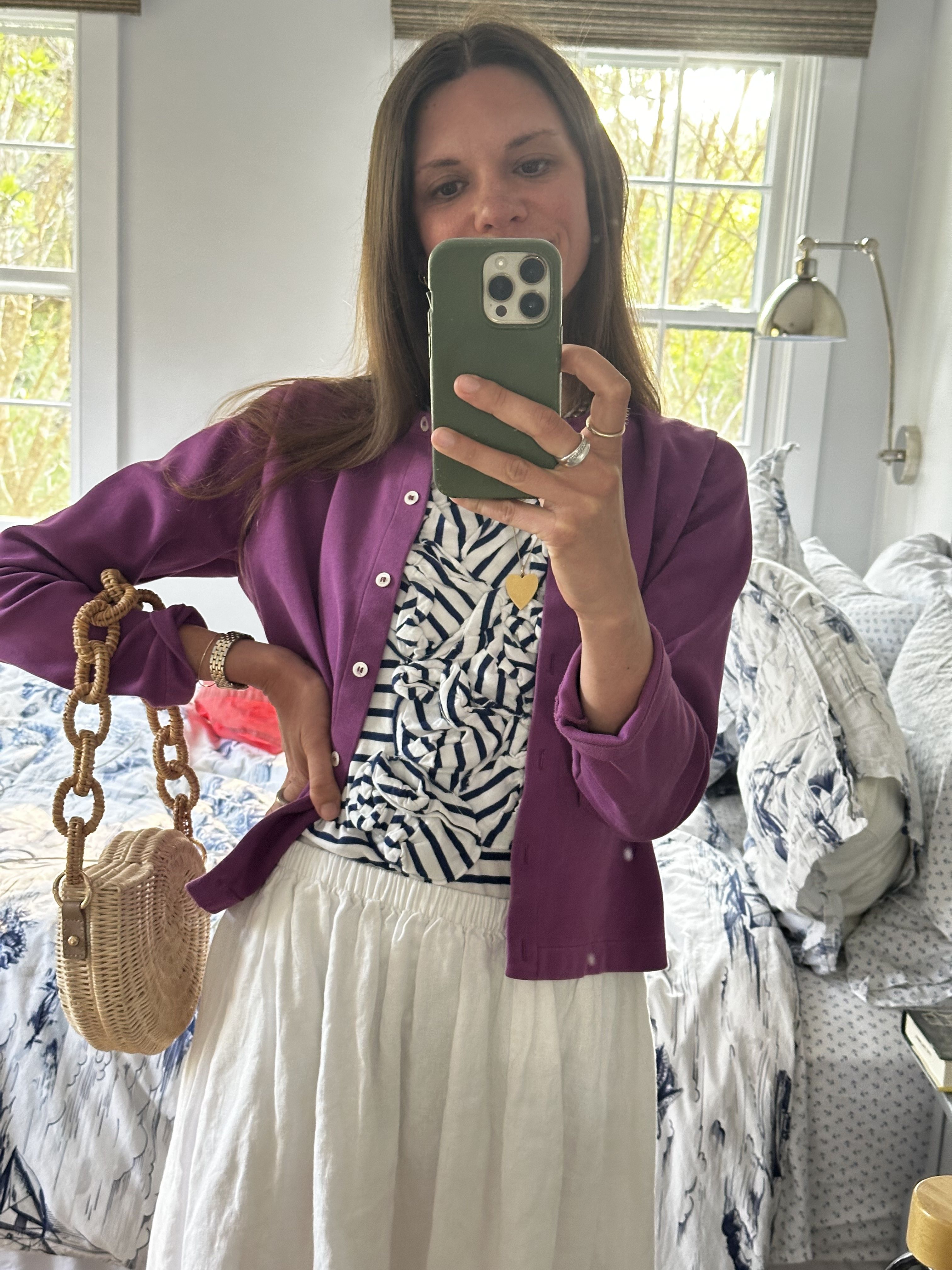 Julia Gall wears a colorful cardigan and white skirt