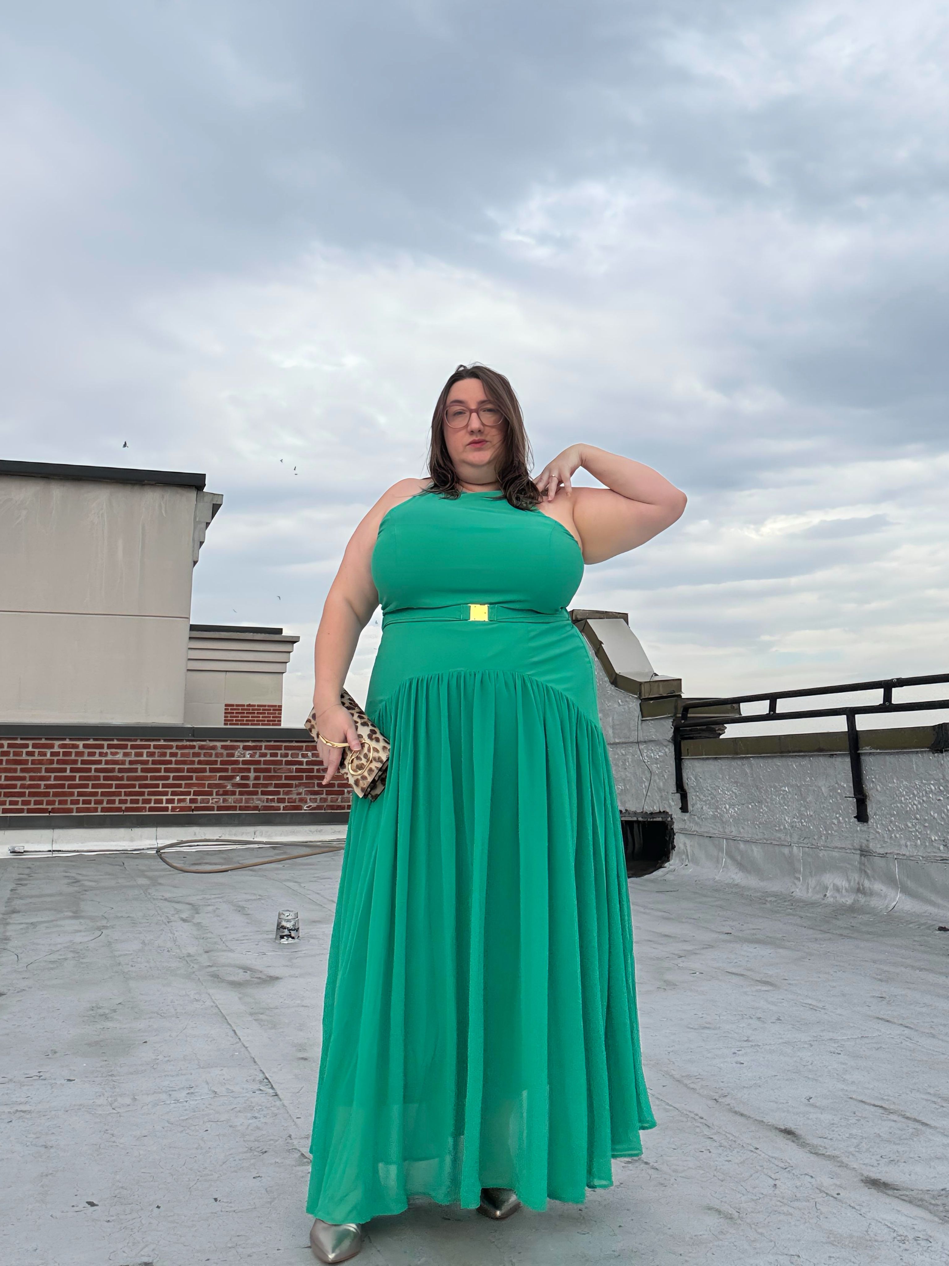 Sarah Chiwaya poses in a drop-waist maxi dress in mint green with an animal print clutch