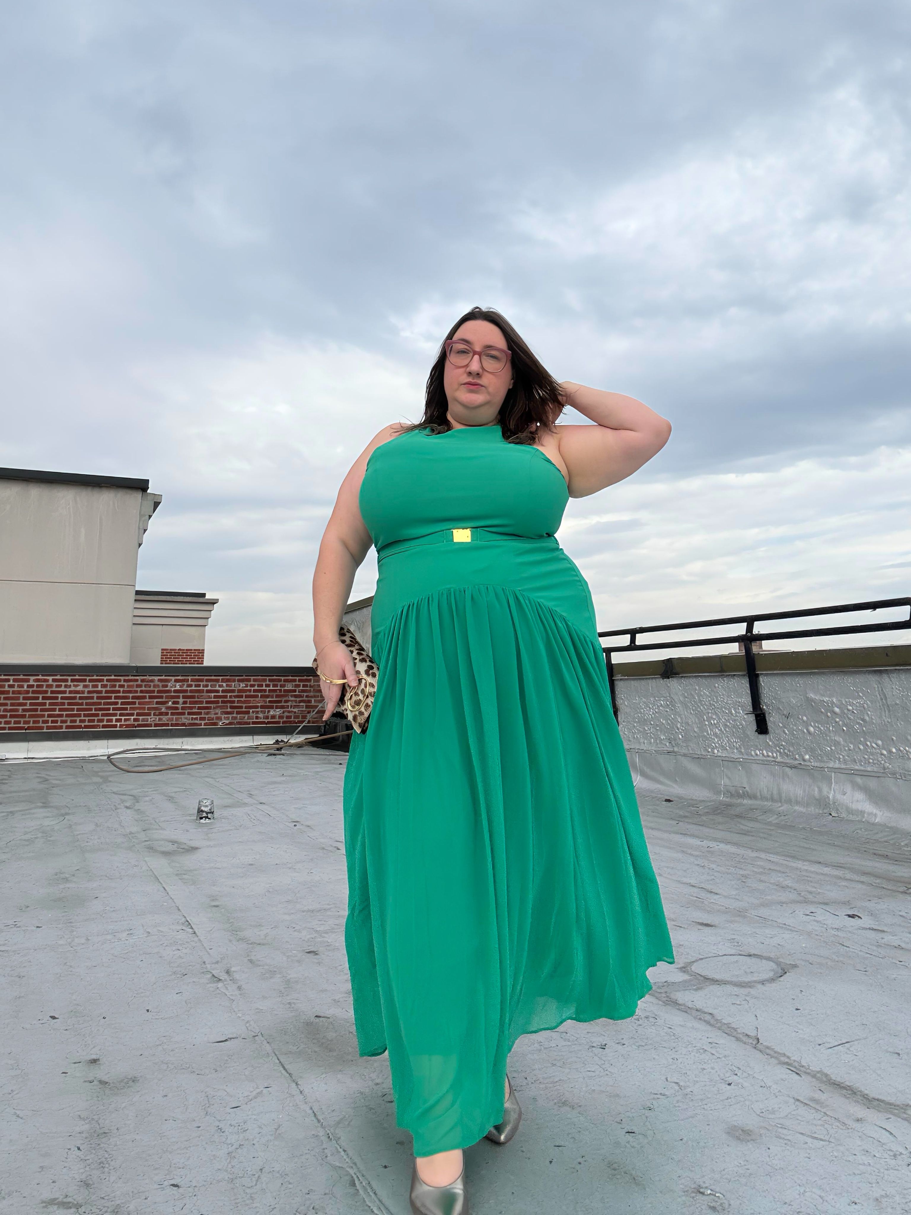 Sarah Chiwaya wears a drop-waist green dress with an animal-print clutch