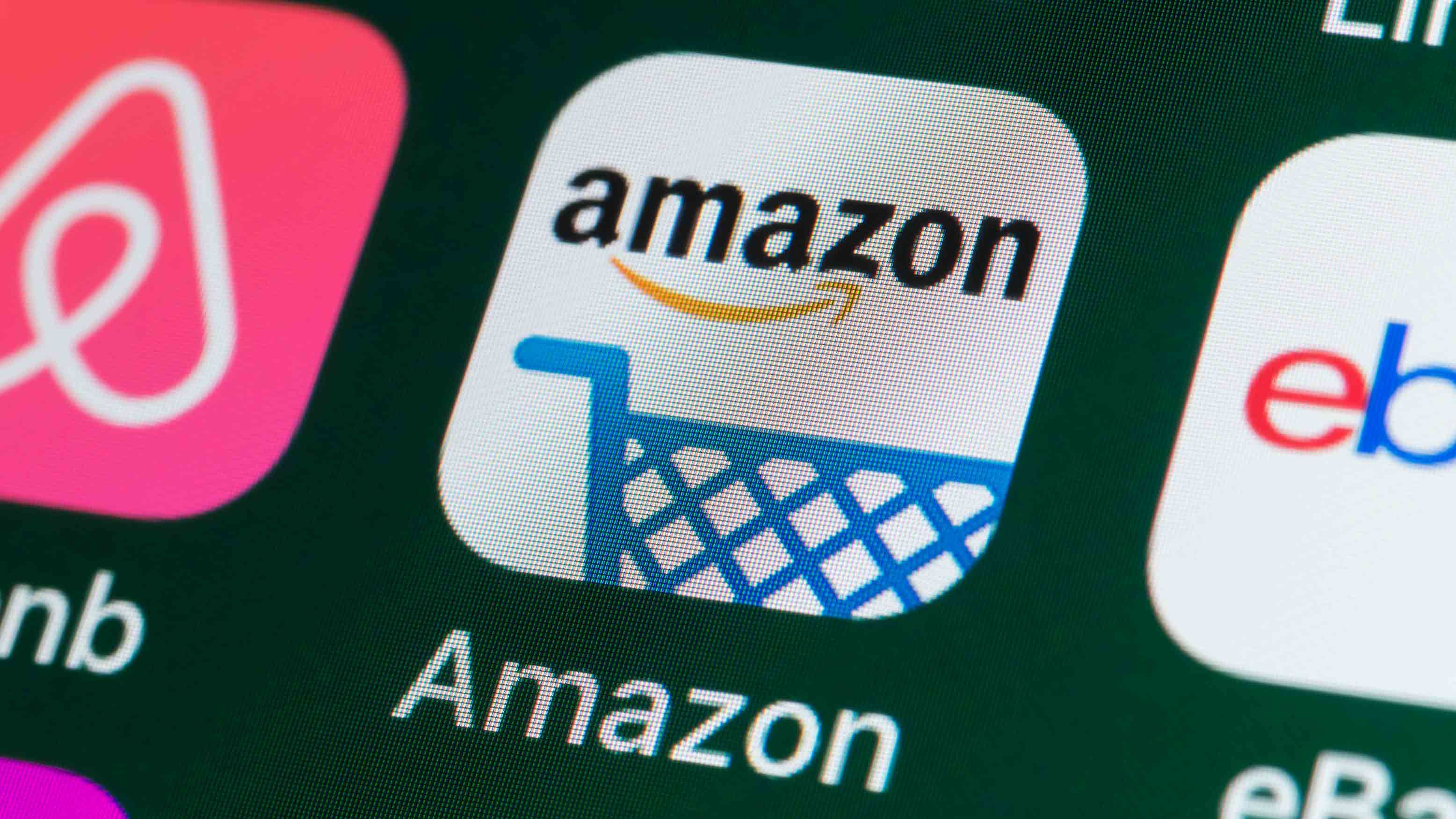 The buttons of the online shopping app Amazon, surrounded by Airbnb, ebay, News and other apps on the screen of an iPhone.