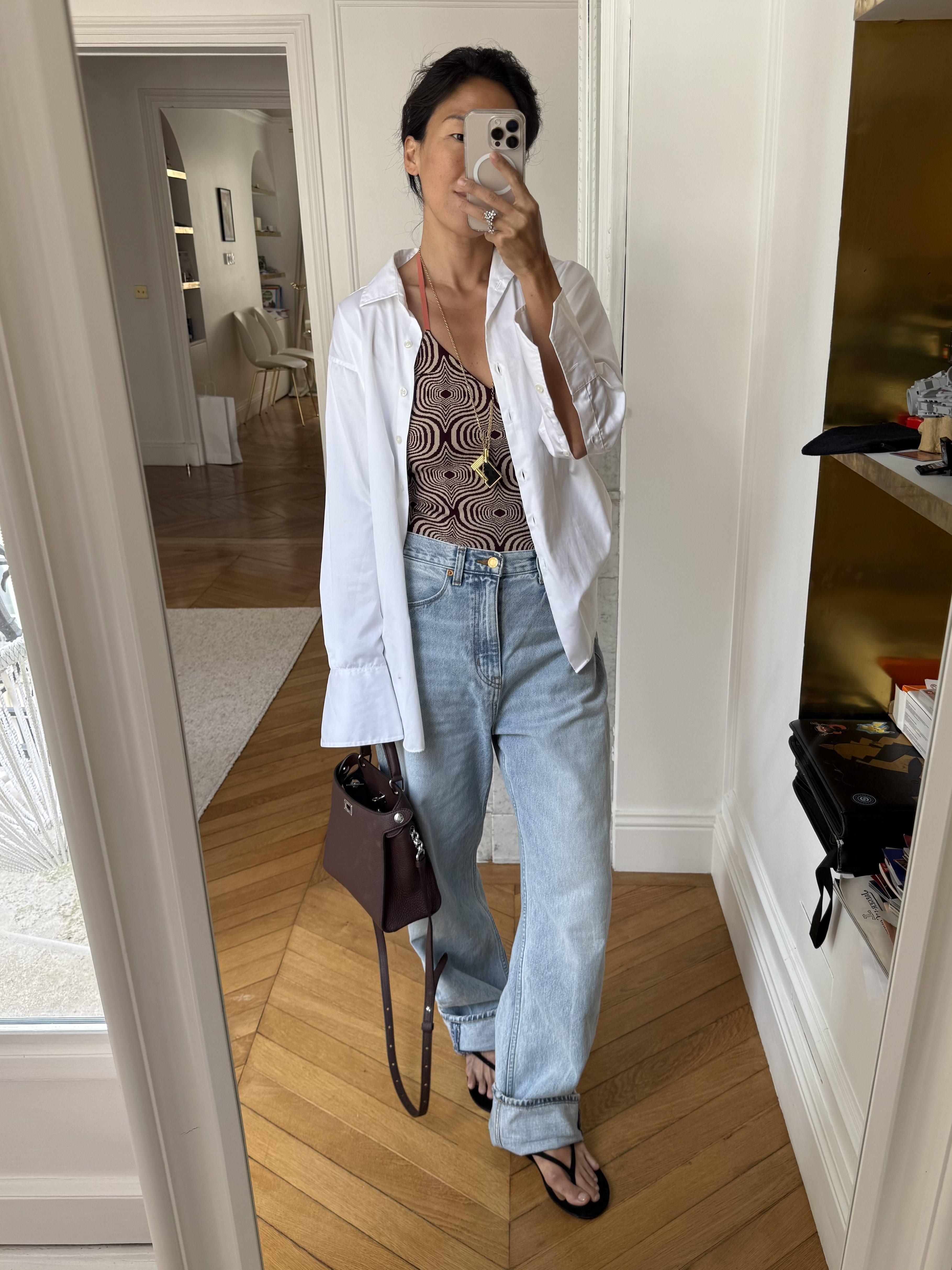 Irene Kim wears jeans, a white shirt and a bag by Michino