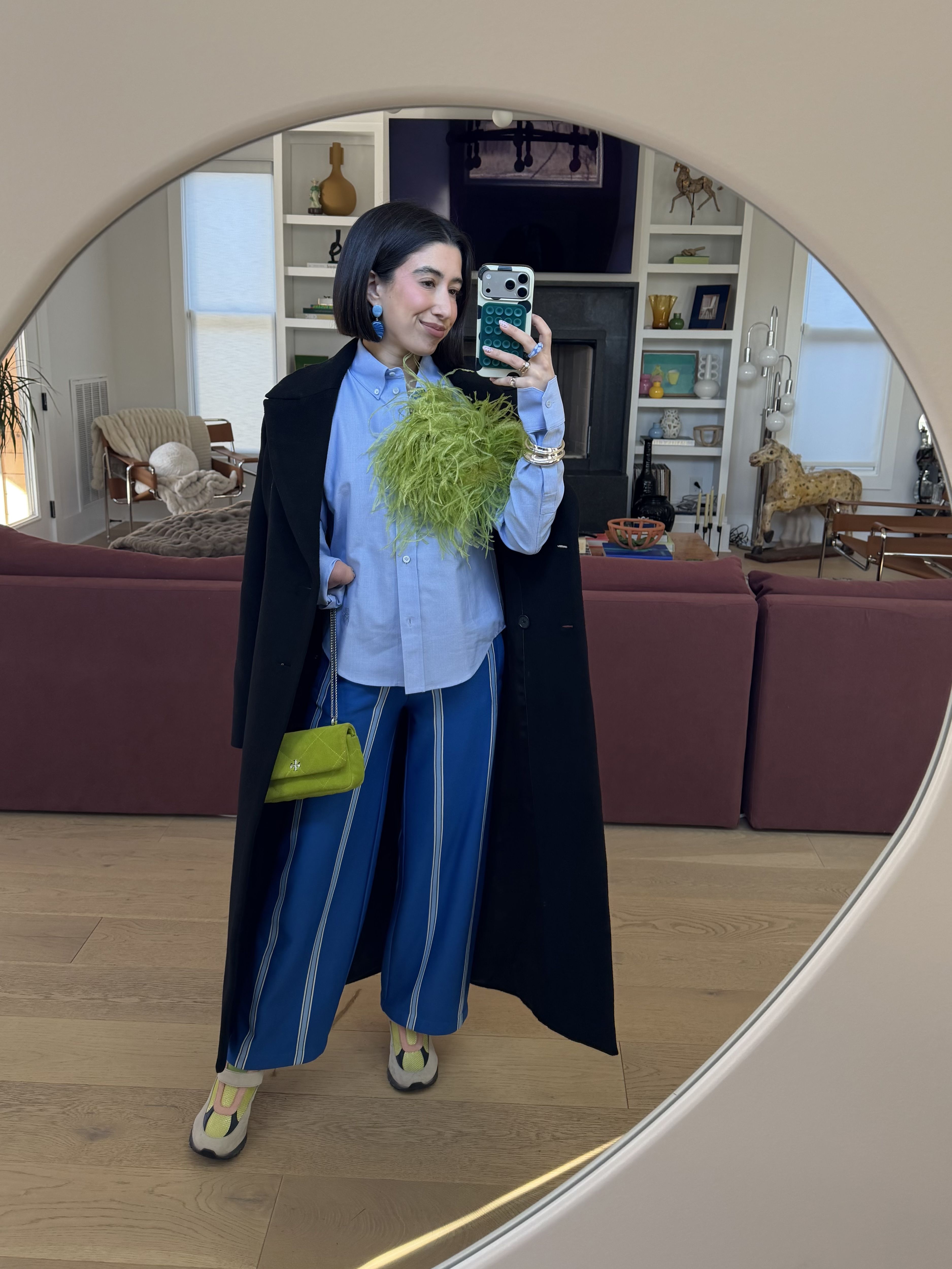 April Lockhart styles an otherwise classic look with an oversized lime green feather brooch