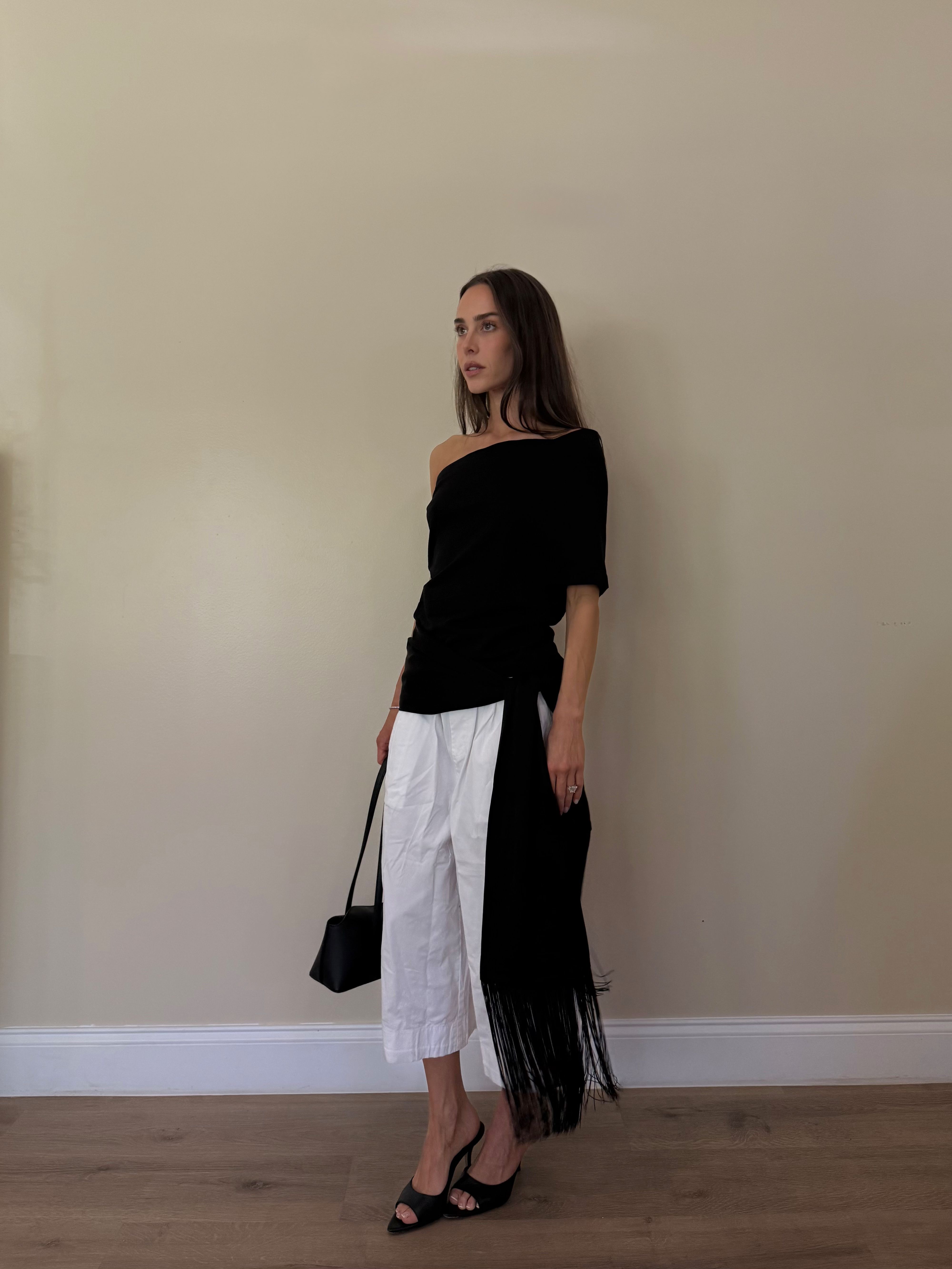 Kira Mackenzie Jackson now has many minimalist tops to choose from, like this asymmetric black top, paired with short white pants