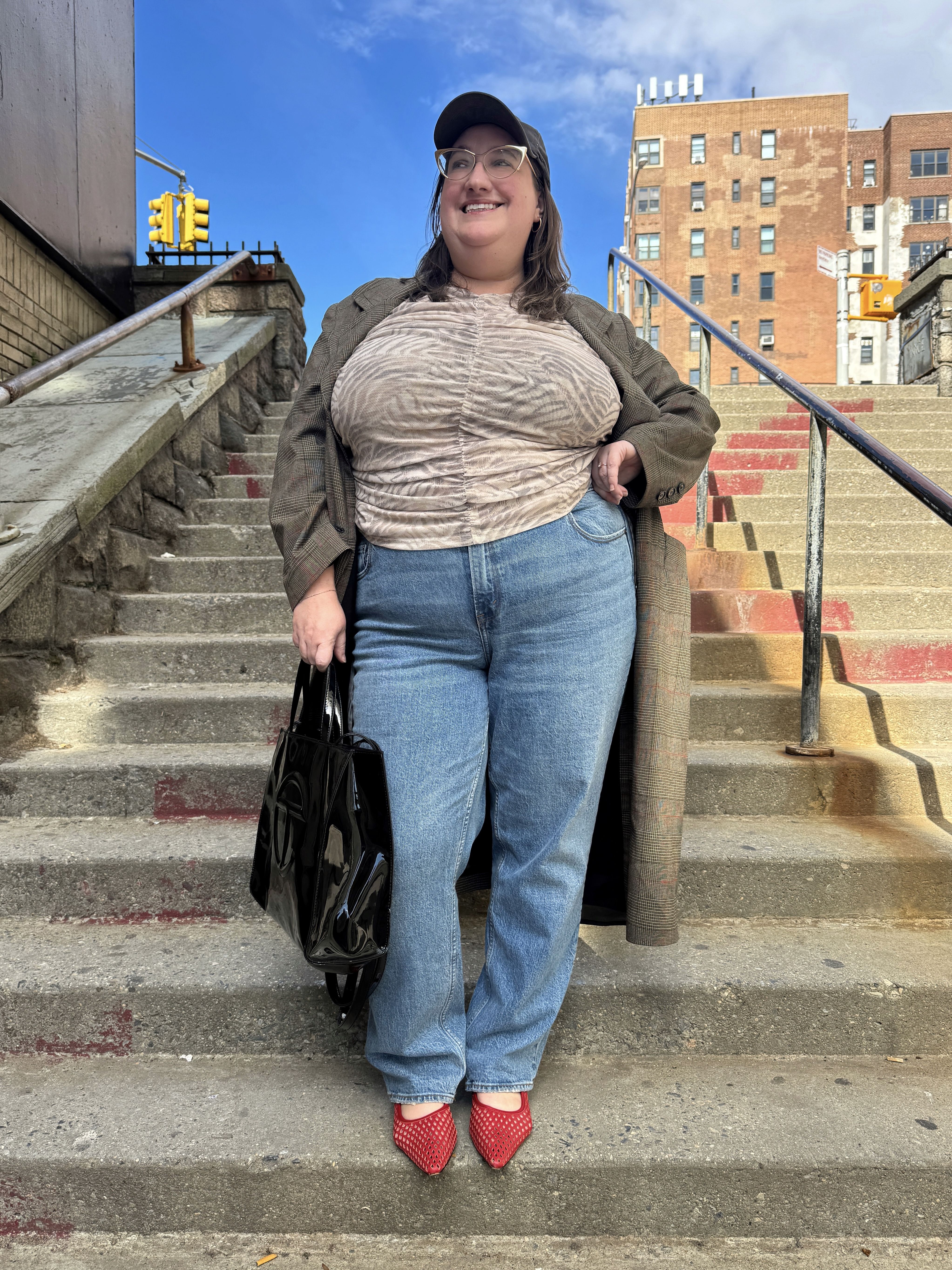 Sarah Chiwaya styles a lightweight longline jacket over straight-leg jeans and red mesh flats for spring