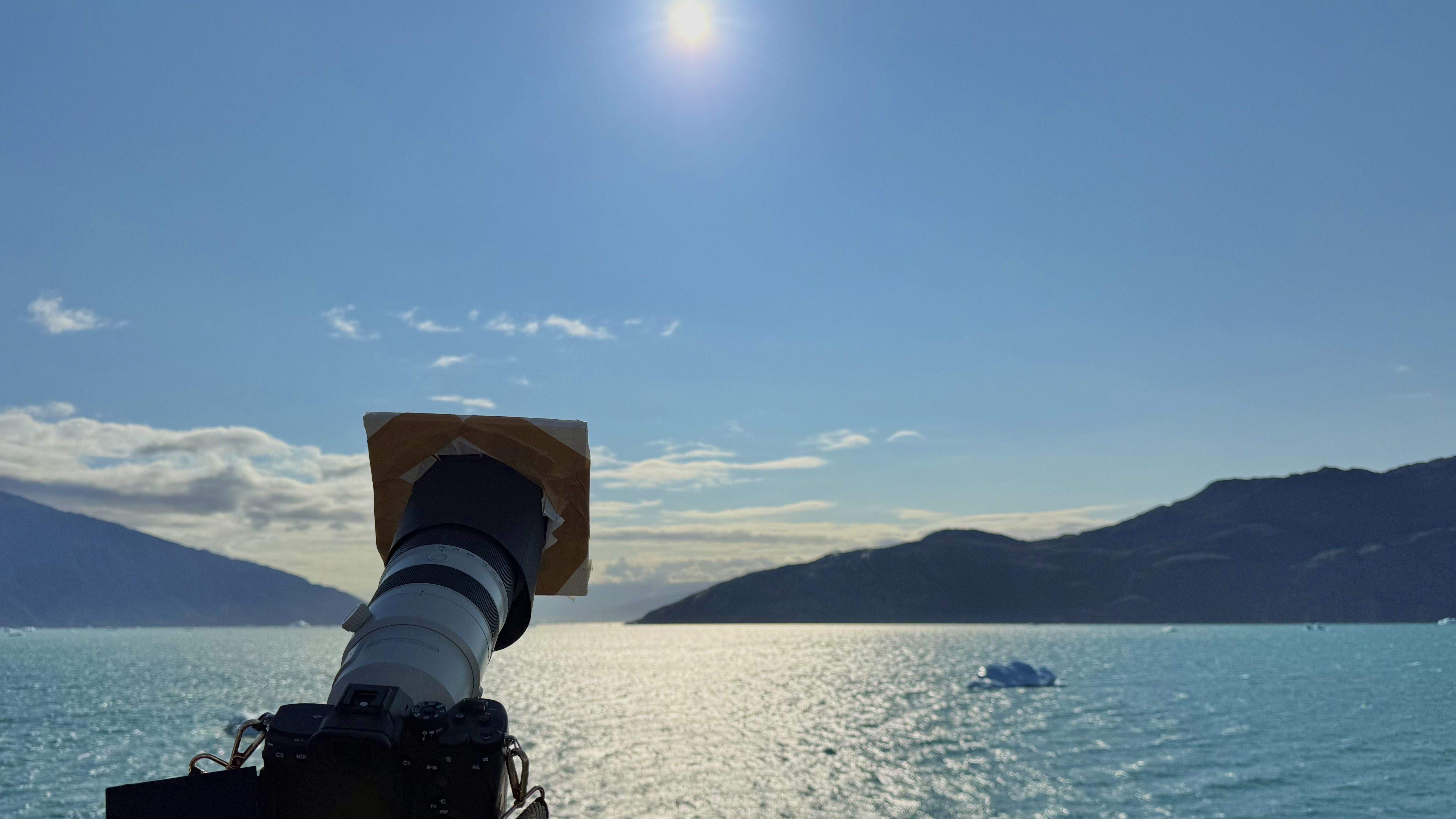 I sailed to Greenland for a total solar eclipse — what I saw left me speechless 5 MyCelestialApp a camera on a tripod and a solar filter point at the sun from the deck of a ship