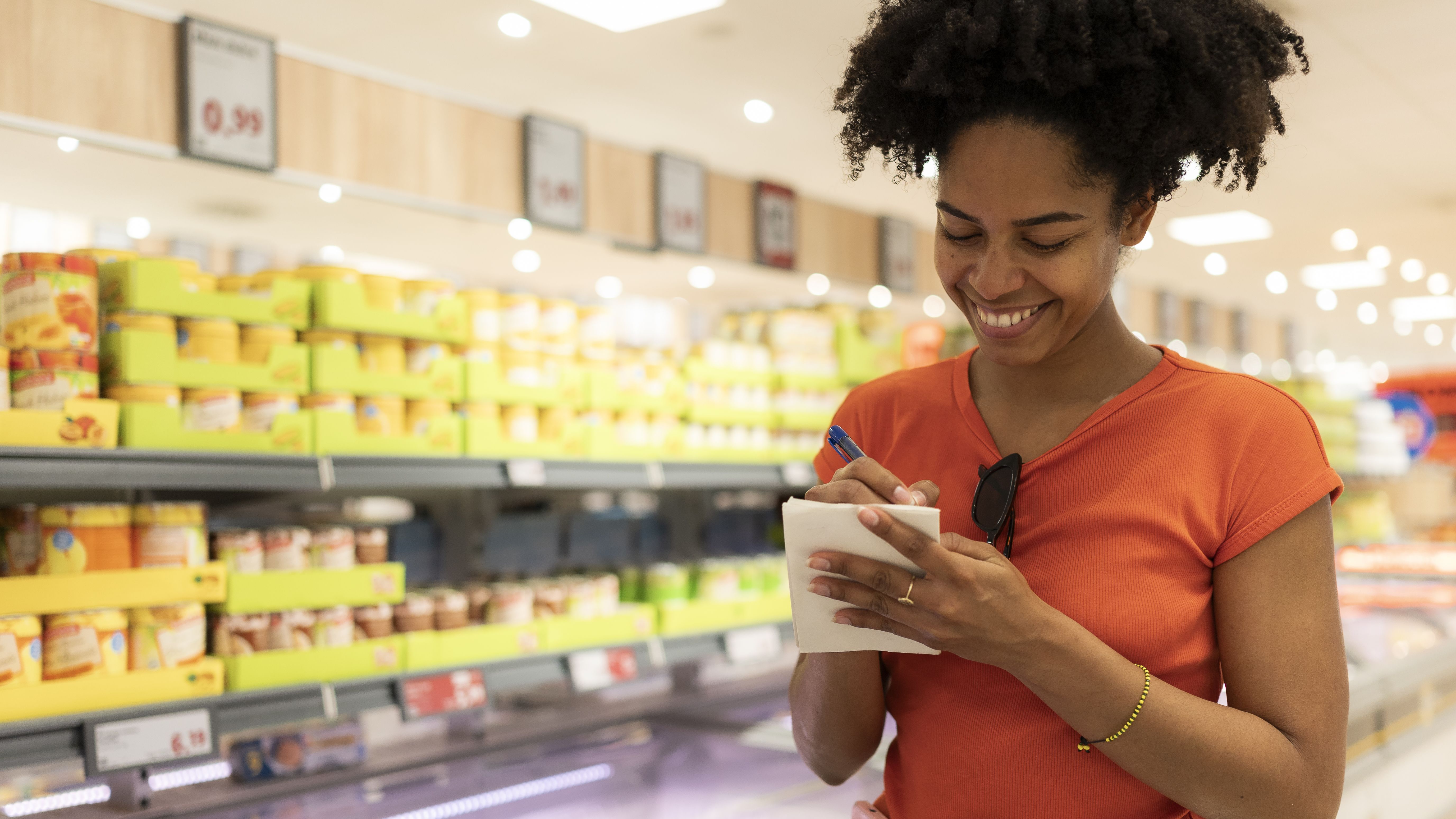 Young adult woman checking grocery list in supermarket