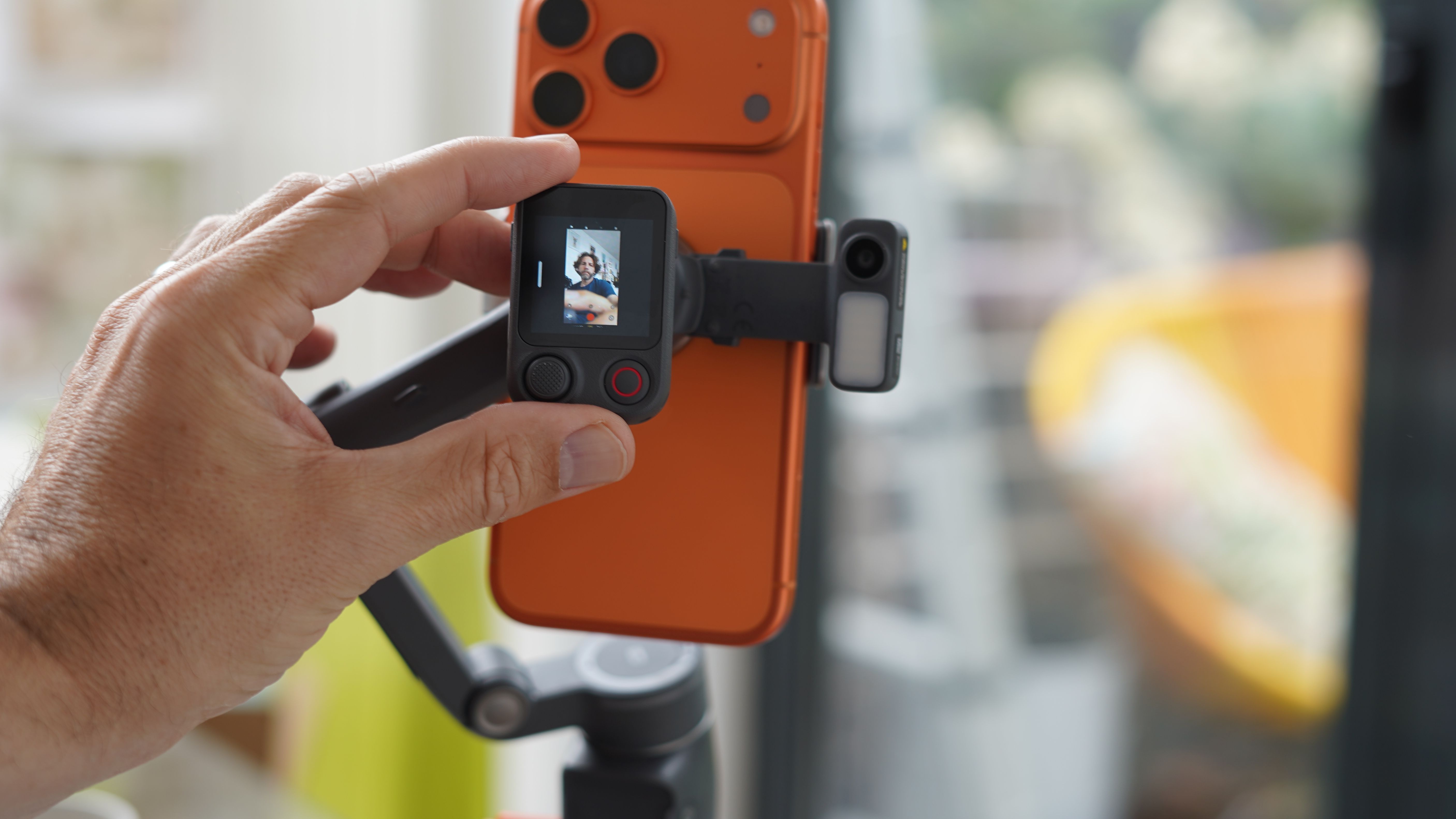 Adam Juniper seen in Osmo Mobile 8P remote screen the other side of iPhone 17 Pro Max