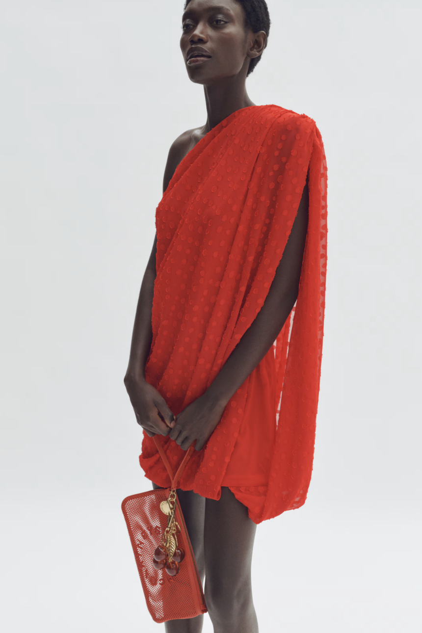 a model wearing a red stella mccartney x hm dress