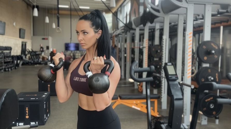 Woman exercises with kettlebells in gym