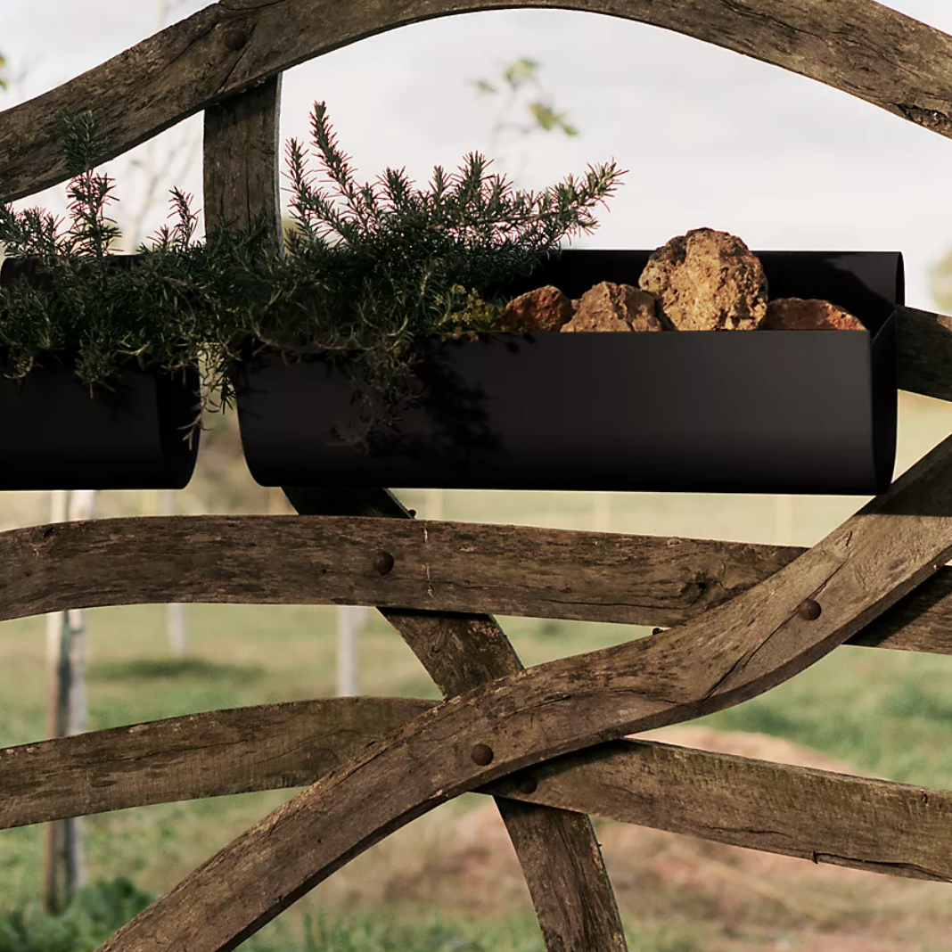 Black balcony planters hung on a gate