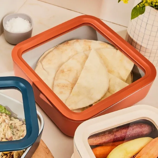 Non toxic Caraway food storage set in a terracotta color, cream and dark blue, showing cooked vegetable rice, flatbreads and root vegetables
