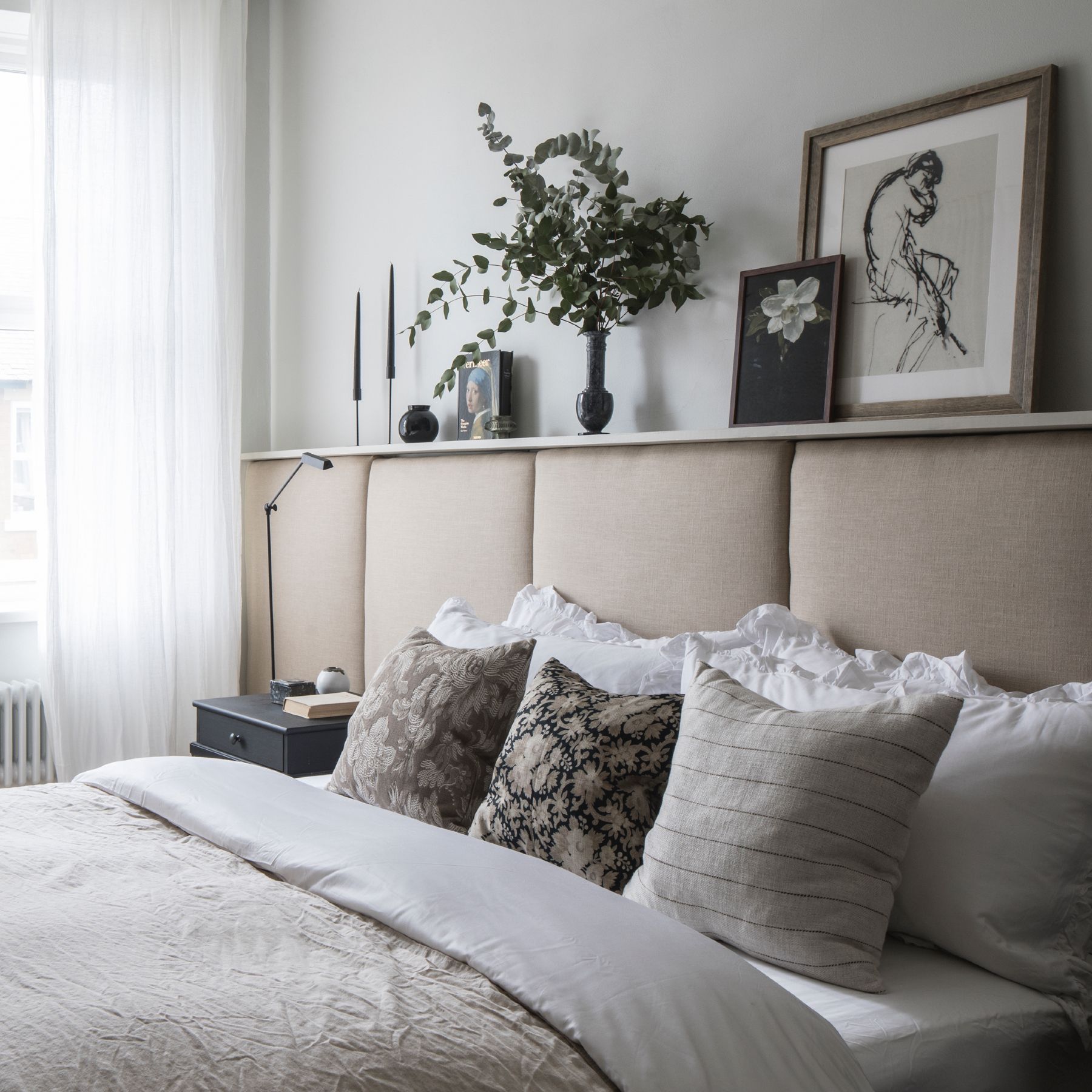 Neutral bedroom with upholstered headboard and voile curtains