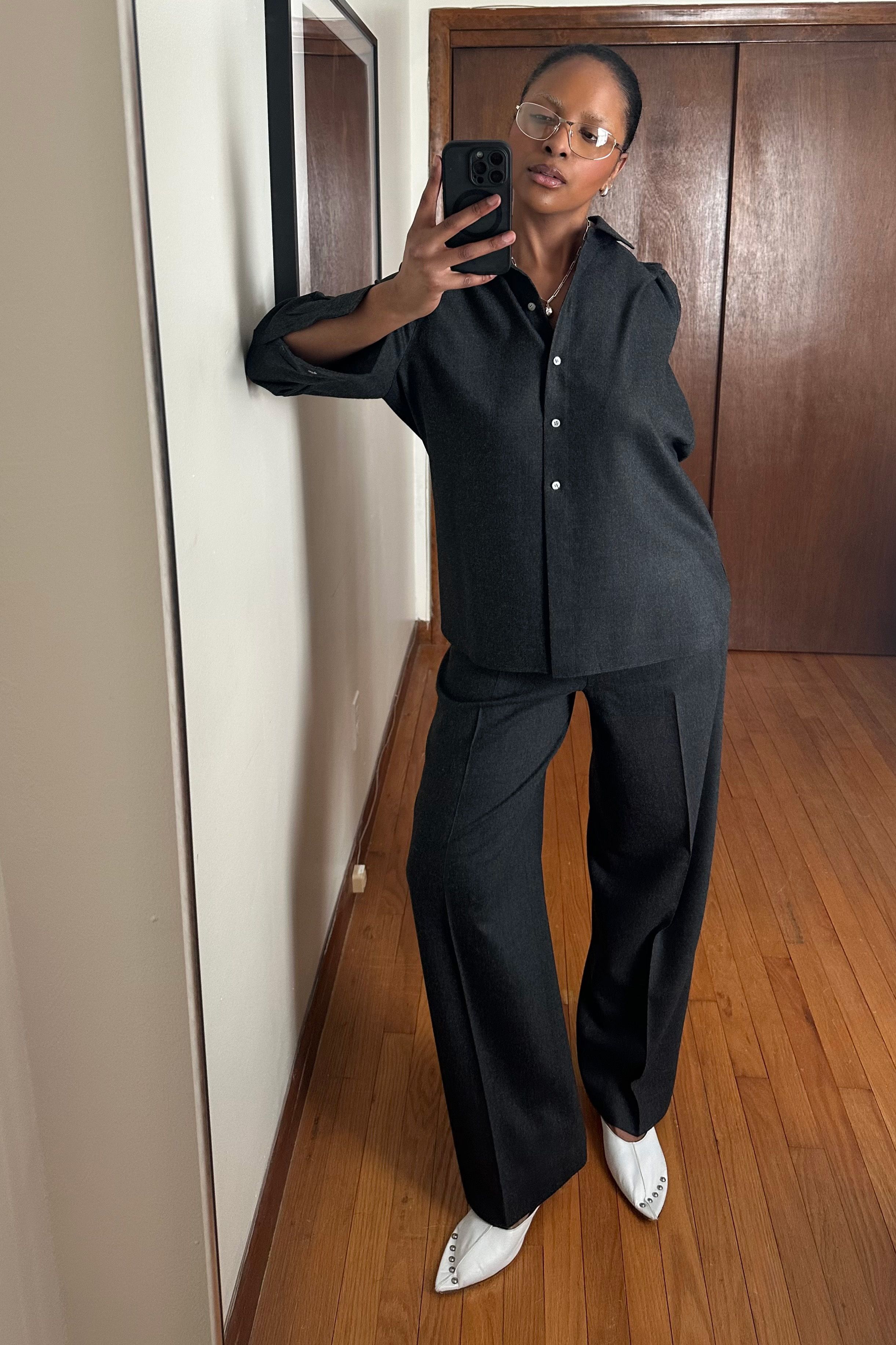 Maya Moore taking a selfie wearing a black shirt, black trousers, and white shoes