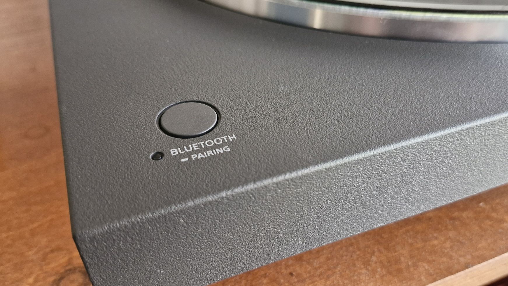 A closeup of the Bluetooth pairing button, that sits flush on the Sony PS-LX3BT turntable.