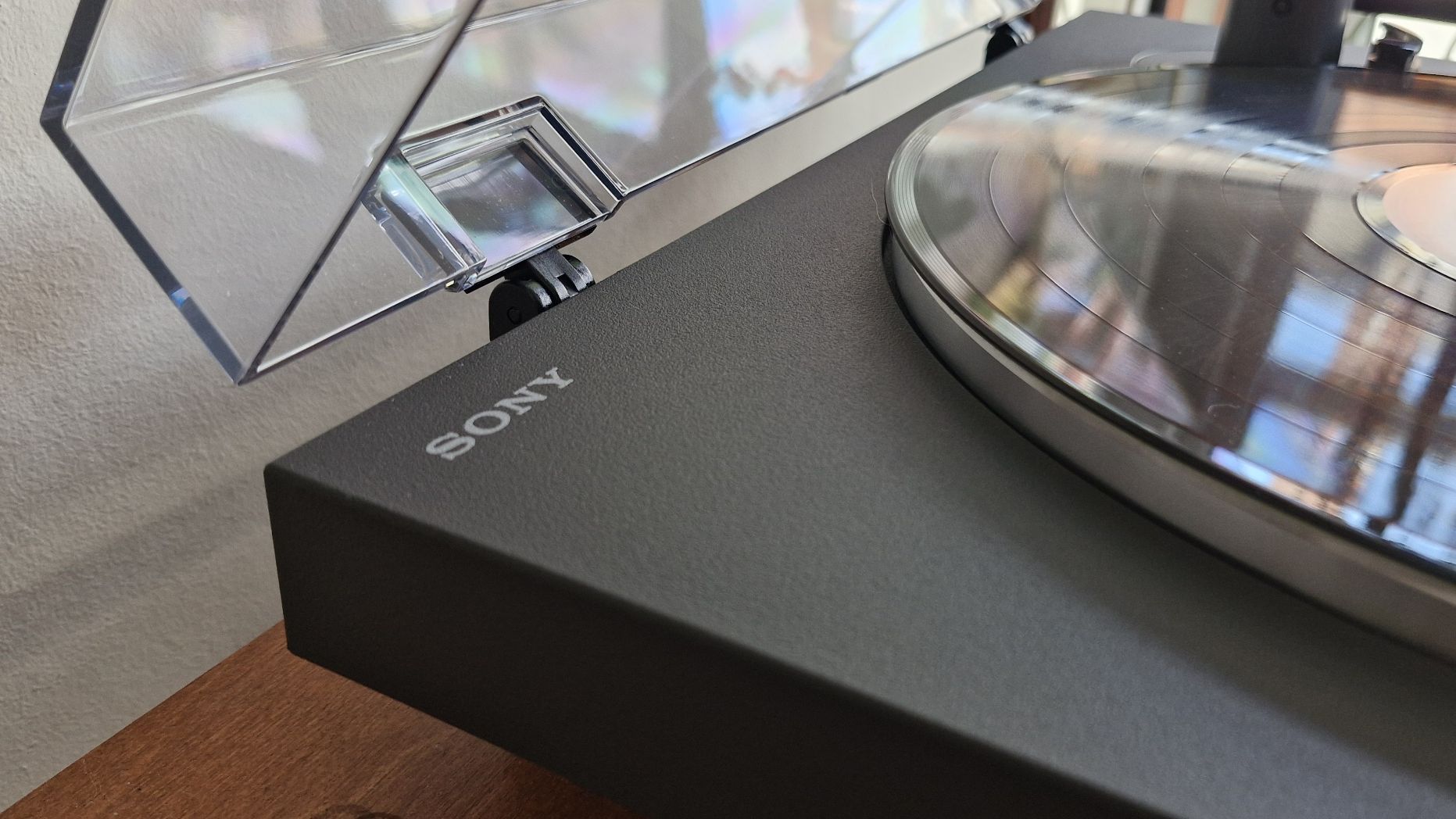 A closeup of the chassis of the Sony PS-LX3BT turntable, with the clear dust cover open.