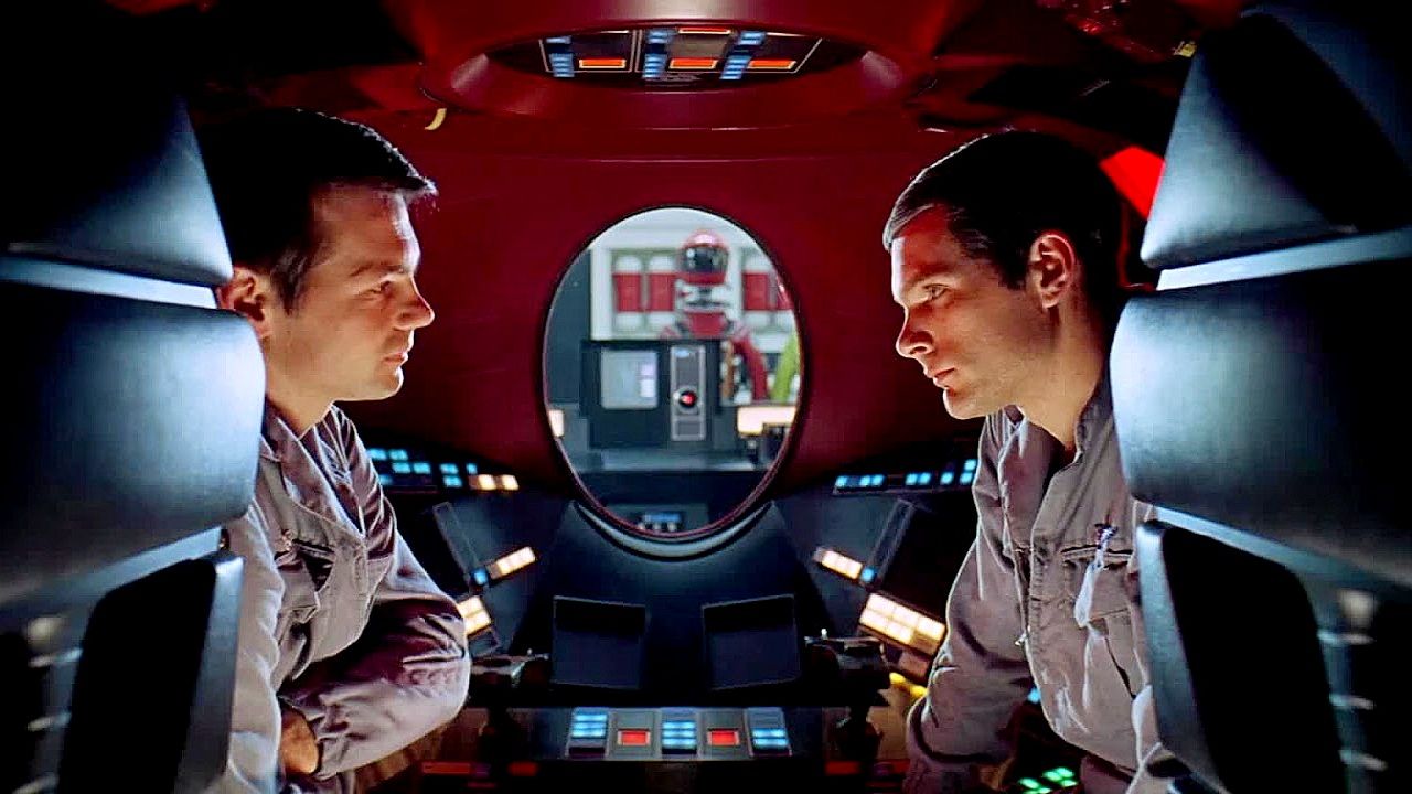 A still from the movie 2001: A Space Odyssey showing astronauts aboard the Discovery ship discussing something.