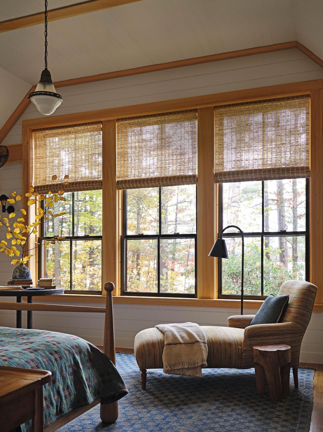 Cream bedroom with yellow framed windows and blue rug