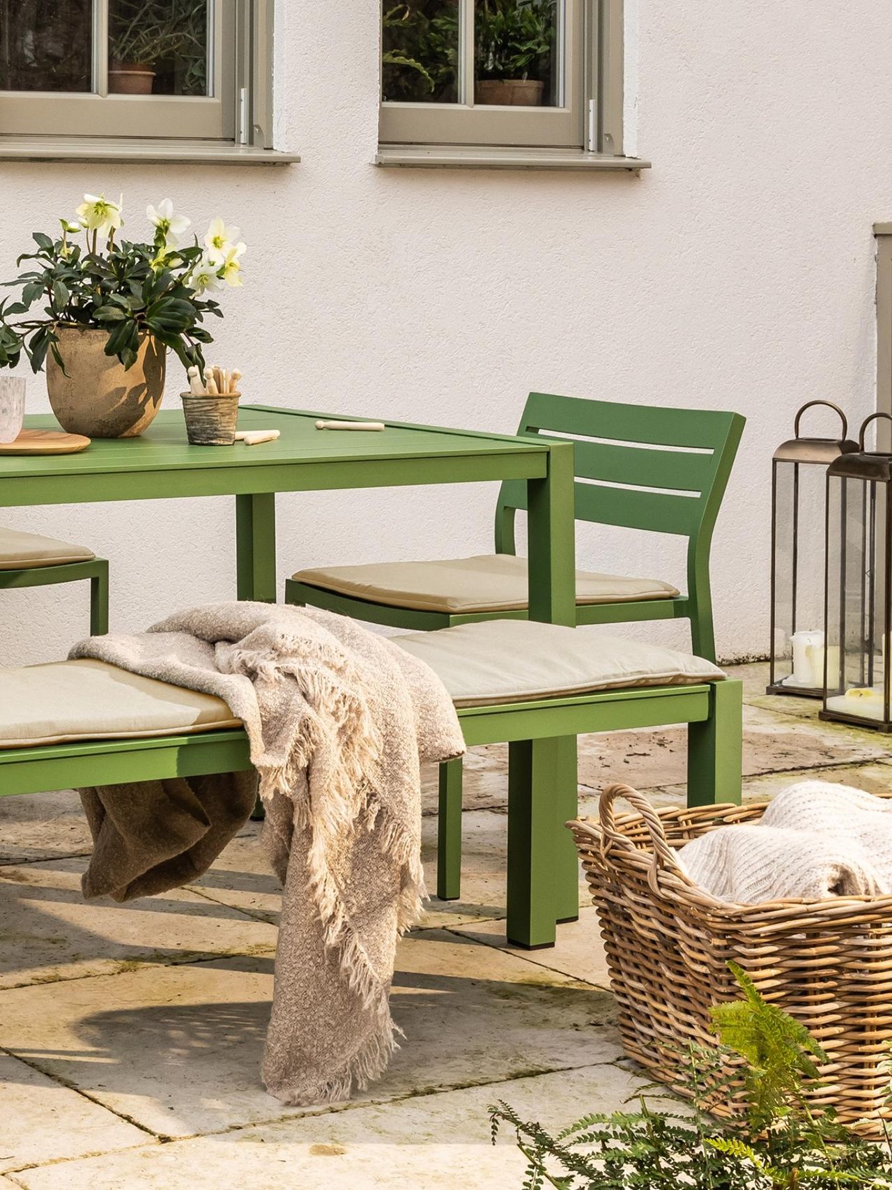 a green garden table on a patio set for breakfast