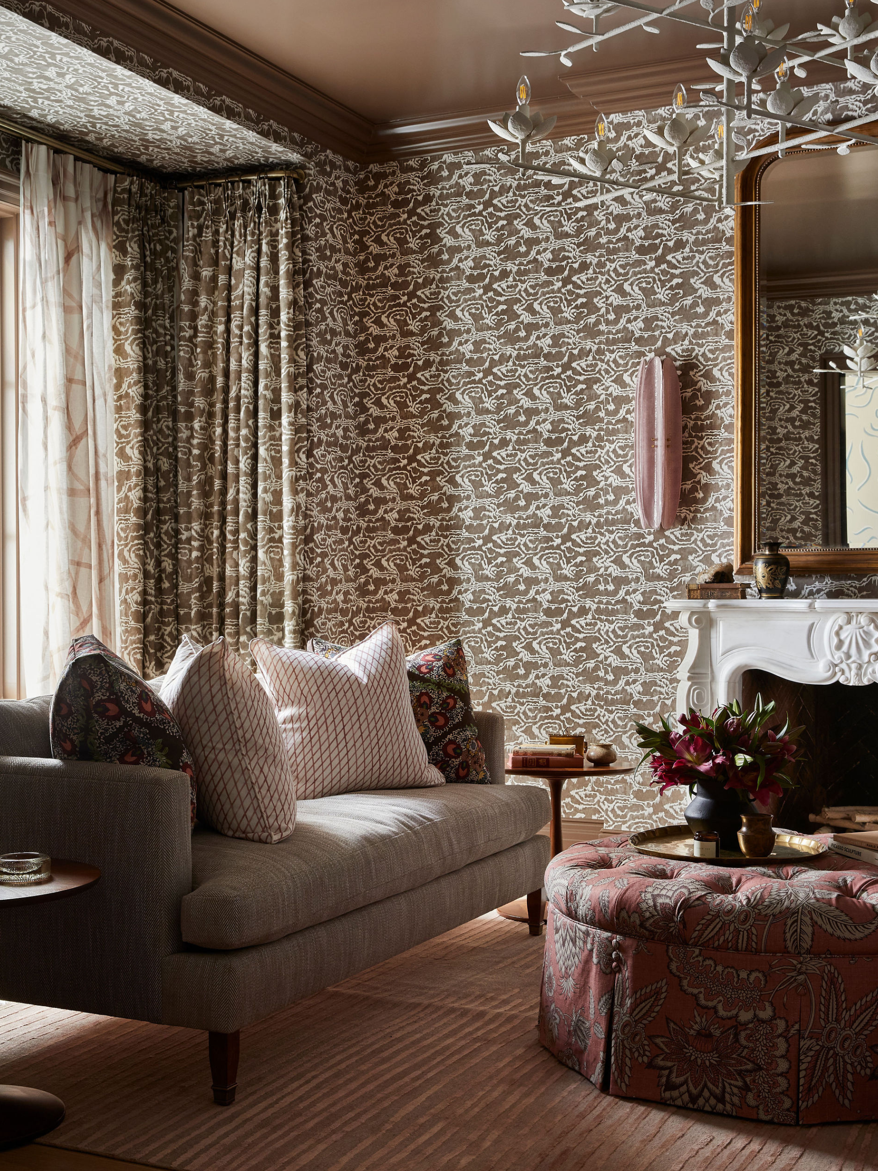 A living room in Toronto with a densely patterned wallpaper drenched across the walls and also the drapes.