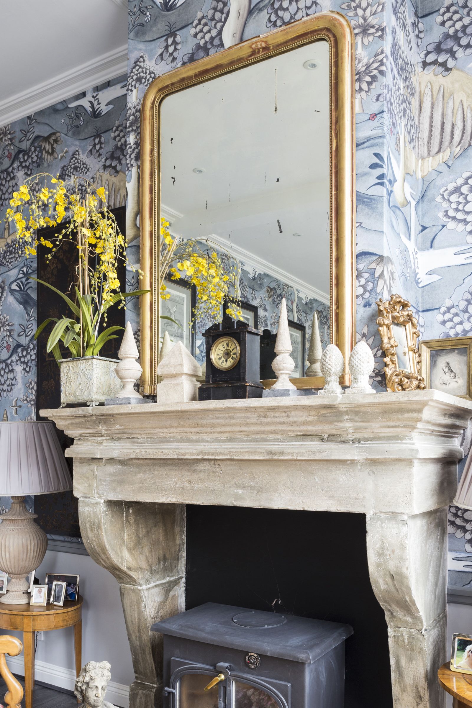 A living room mirror idea with ornate gold frame and blue printed wallpaper