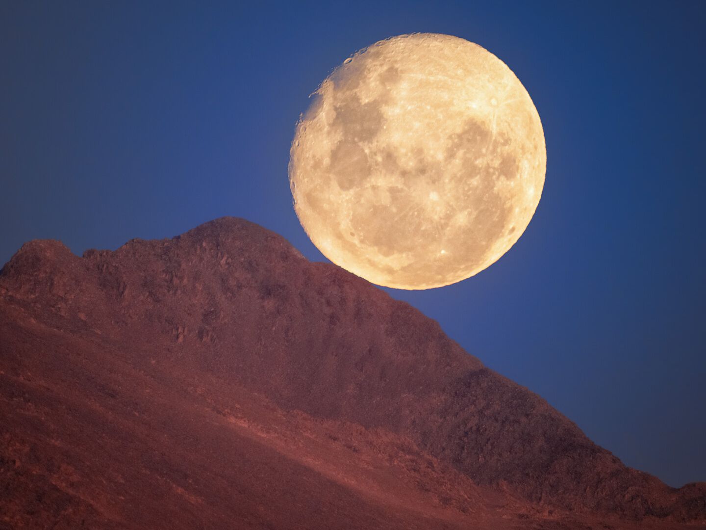 The moon looks set to roll down a ridge photo of the day for Nov