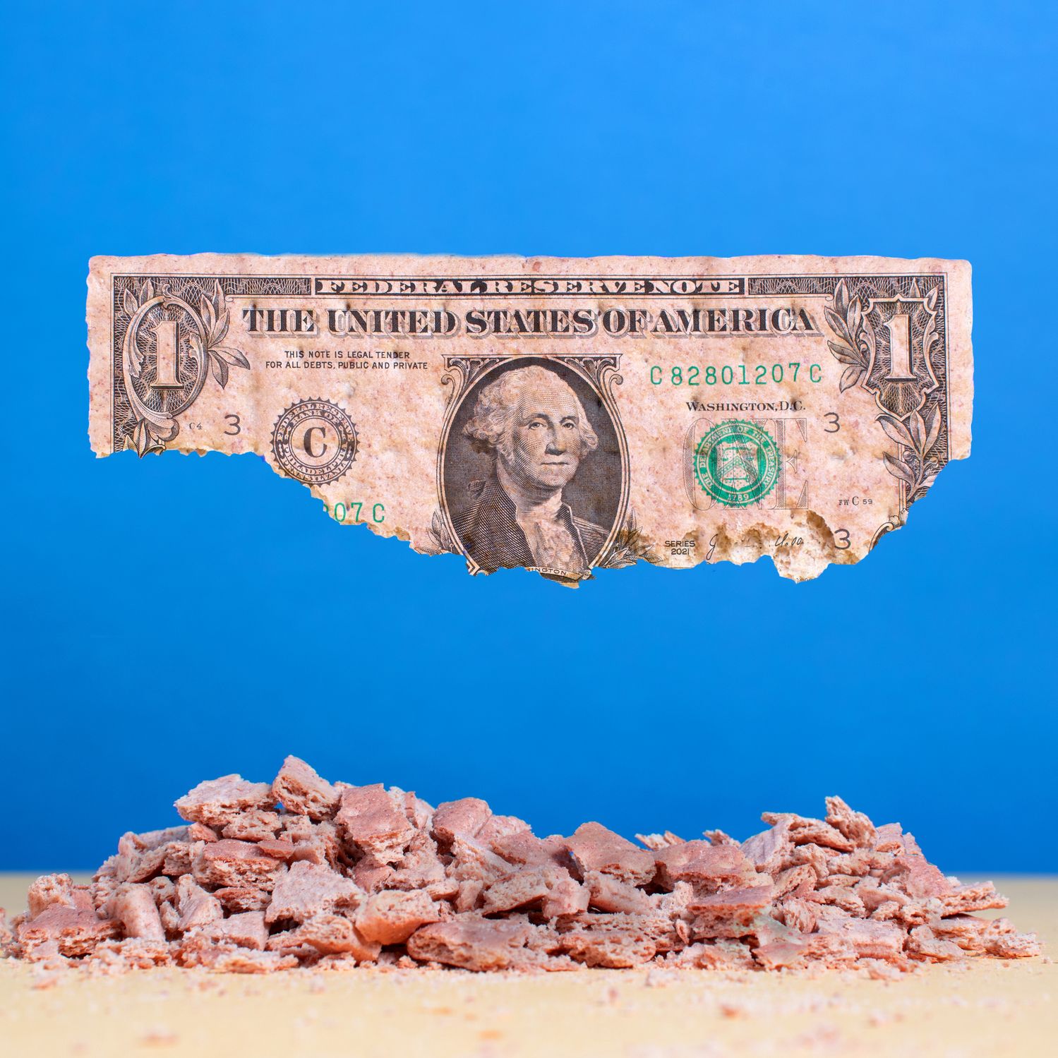 A graphic of a dollar bill crumbling to dust on a blue background