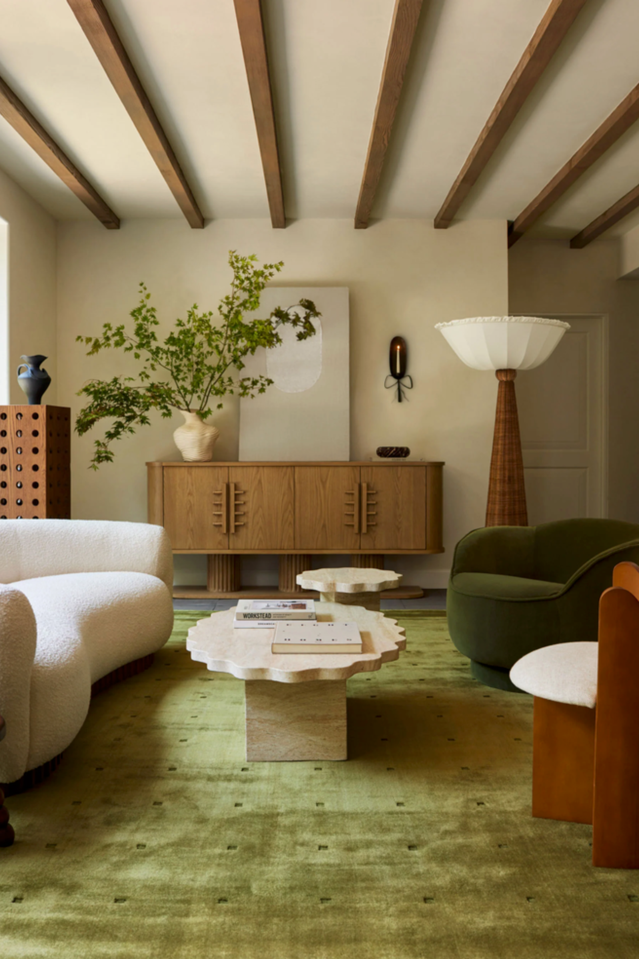 White curved sofa in living room with green rug