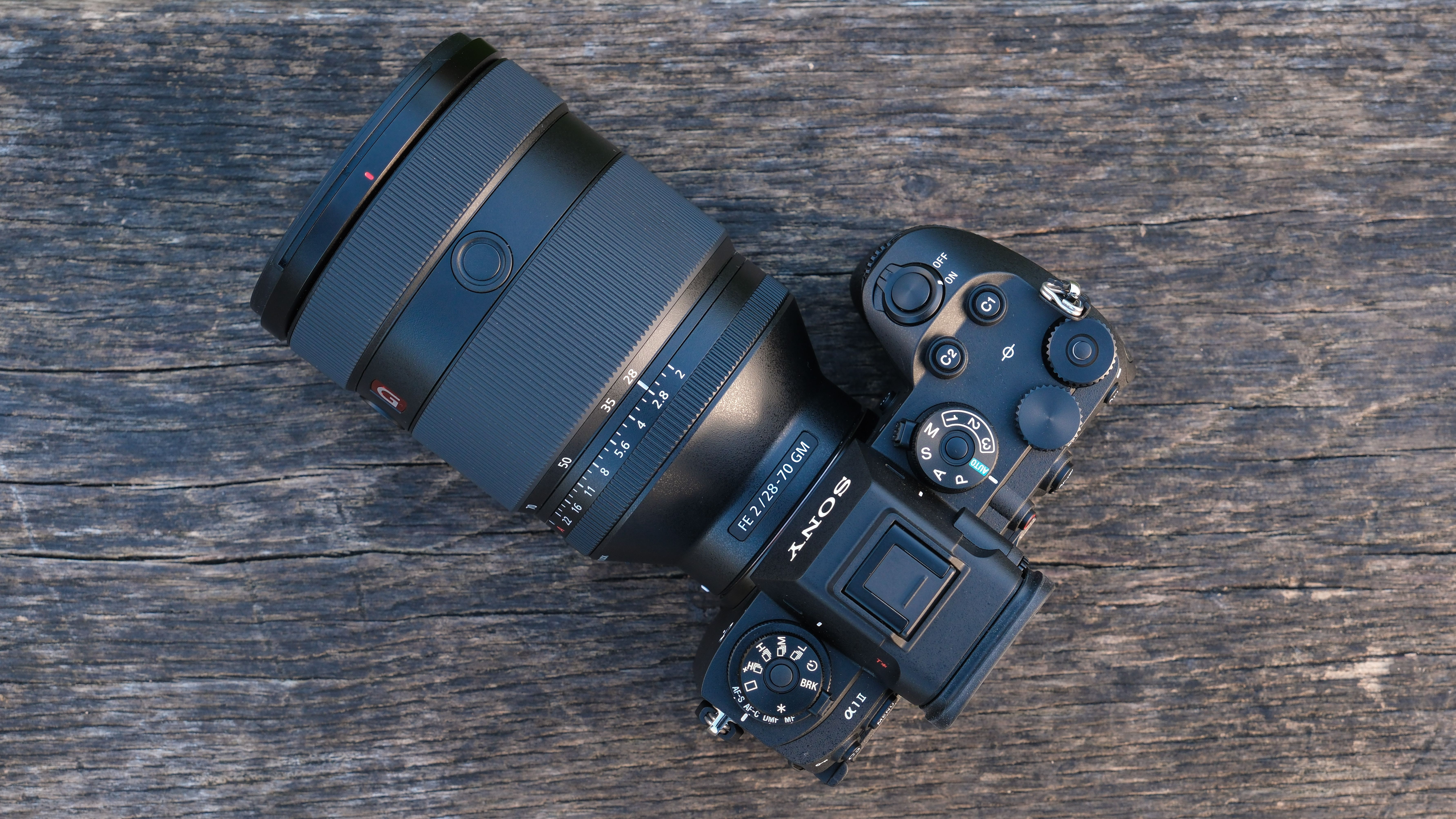 Sony a1 II camera with a Sony FE 28-70mm f/2 GM lens attached on a wooden bench