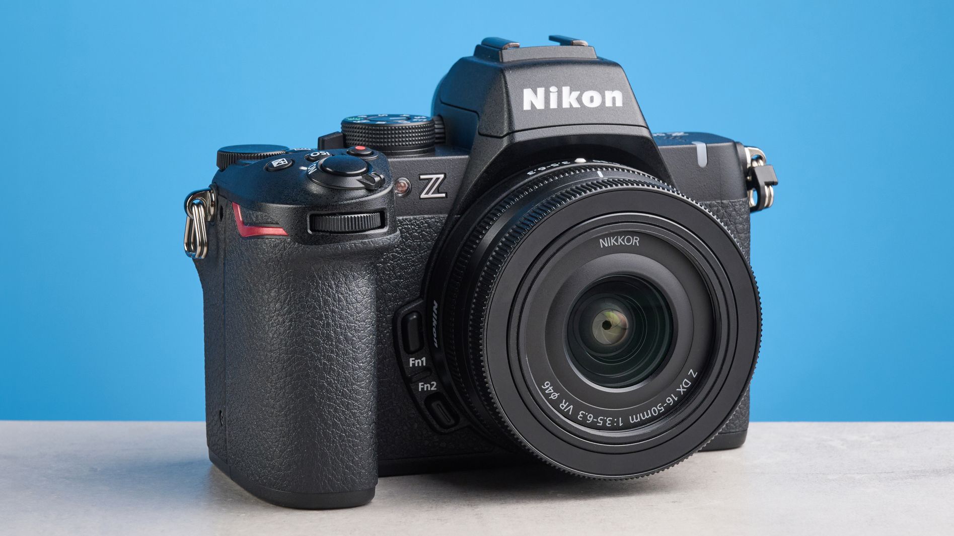 The Nikon Z50II on a stone surface with a blue background
